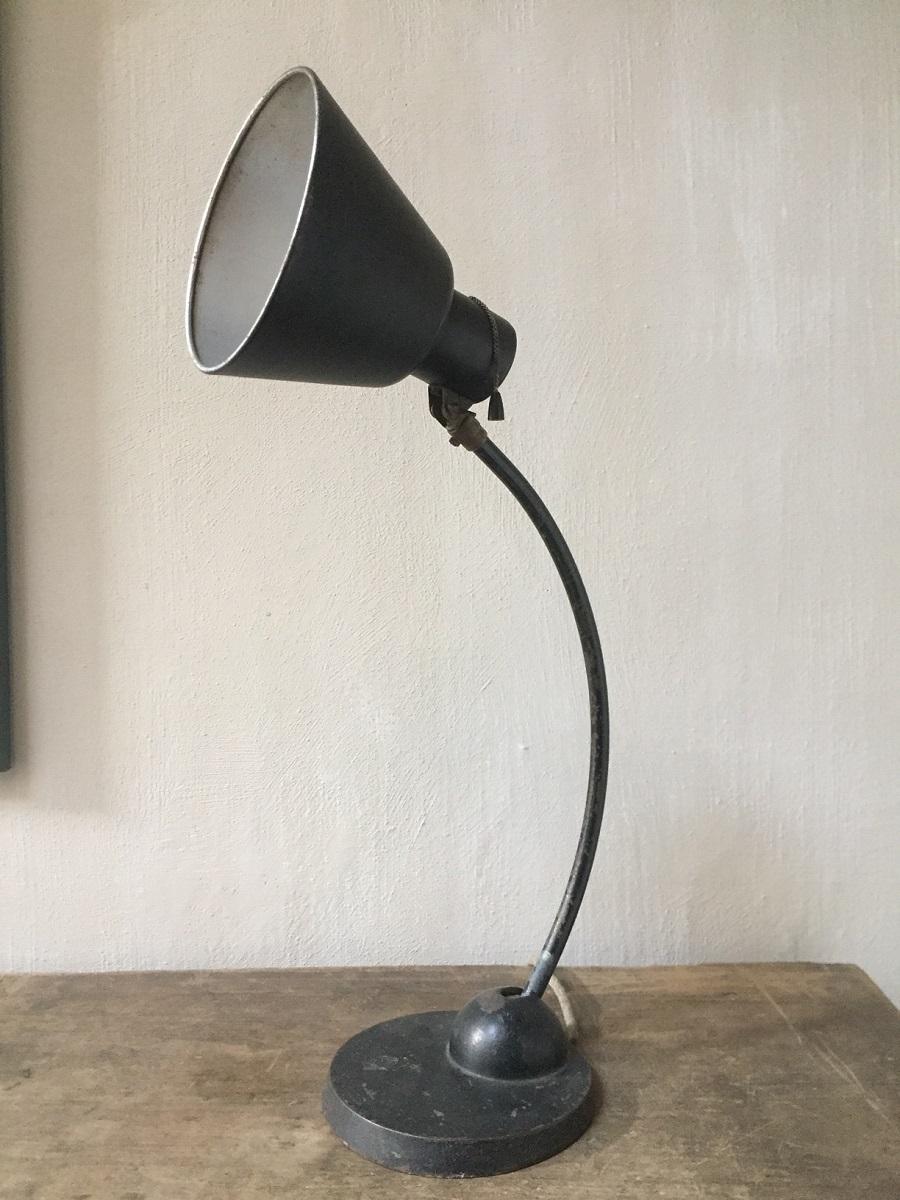 A Schaco tablelamp with adjustable shade and Stand. Schaco was a German manufacturer of Industrial lightning who worked in the modernist style of the period. This tablelamp is completely original and functional. The black paint has a nice patina.
