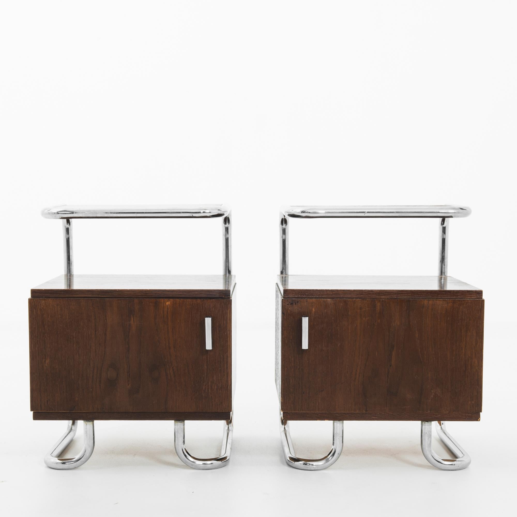 This pair of wood and metal bedside tables was made in Germany, circa 1930. With their combination of materials and forms, these pieces will bring style and elegance to any space. The curves of the top shelf and legs soften the crisp lines of the