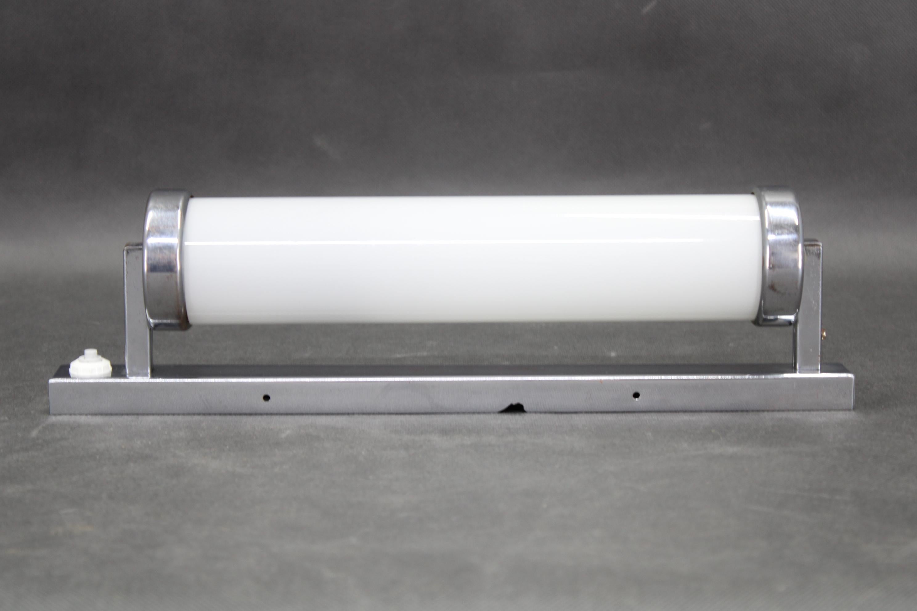 Applique tubulaire originale du Bauhaus, fabriquée en Tchécoslovaquie dans les années 1930, avec un tube en verre et un cadre en métal chromé. Très bon état vintage avec des signes mineurs d'utilisation. Conçue pour une ampoule E26 ou E27 et