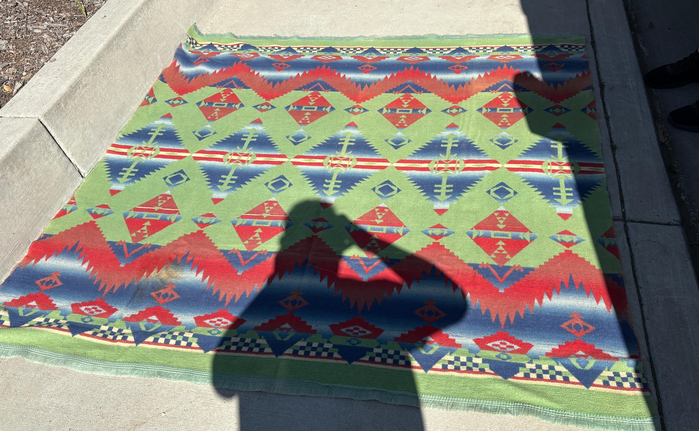 Manta de campamento india de baliza azul, verde y roja fabricada en algodón en los años 30. Gran desgaste en los bordes por la edad y el uso. El interior de la baliza está muy bien, sin desgarros en el tejido. 