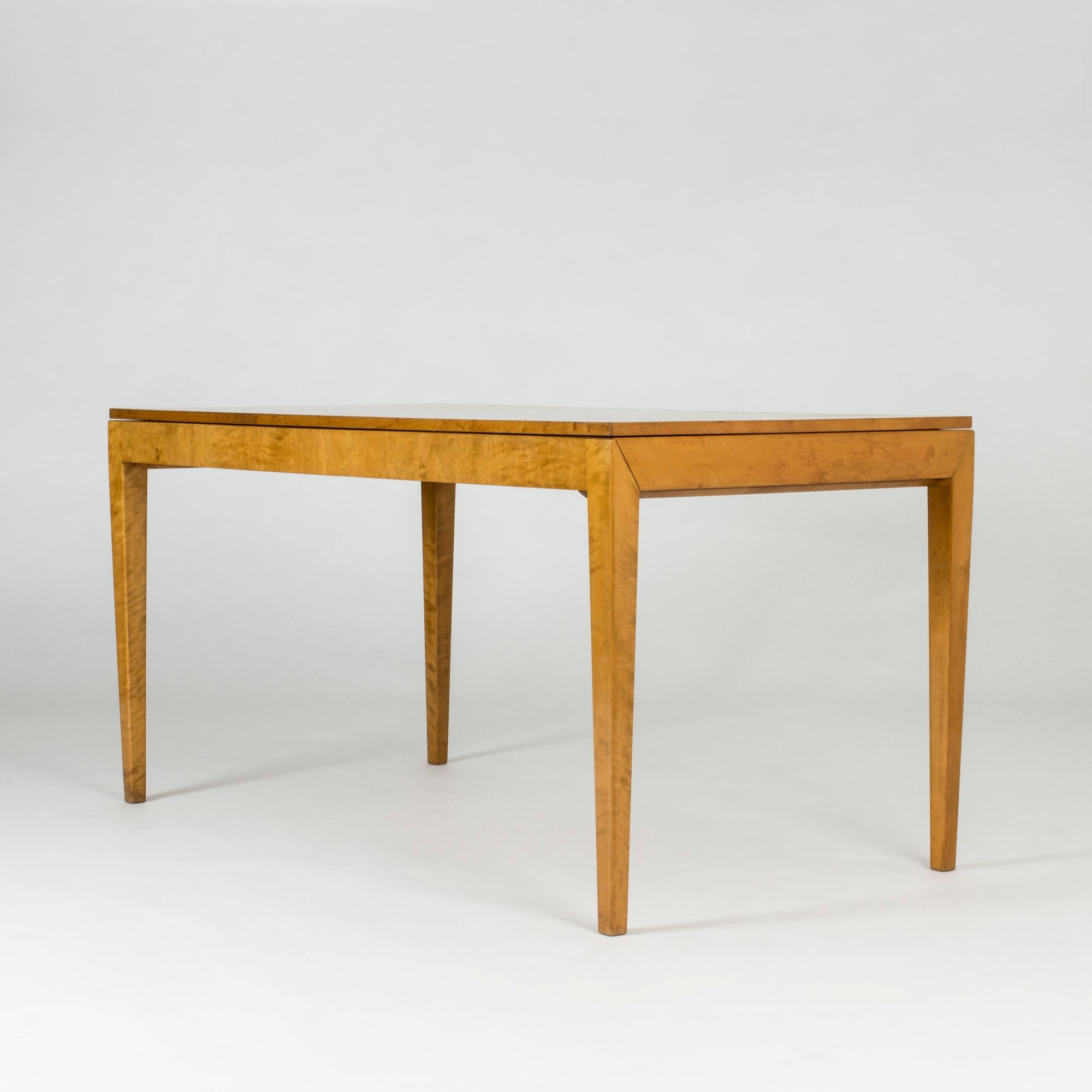 Striking functionalist dining table by Axel Larsson with diagonal joinery at the top of the legs. The table is made from beech with two extension leaves cleverly hidden under the tabletop. Beautiful life in the wood grain.
