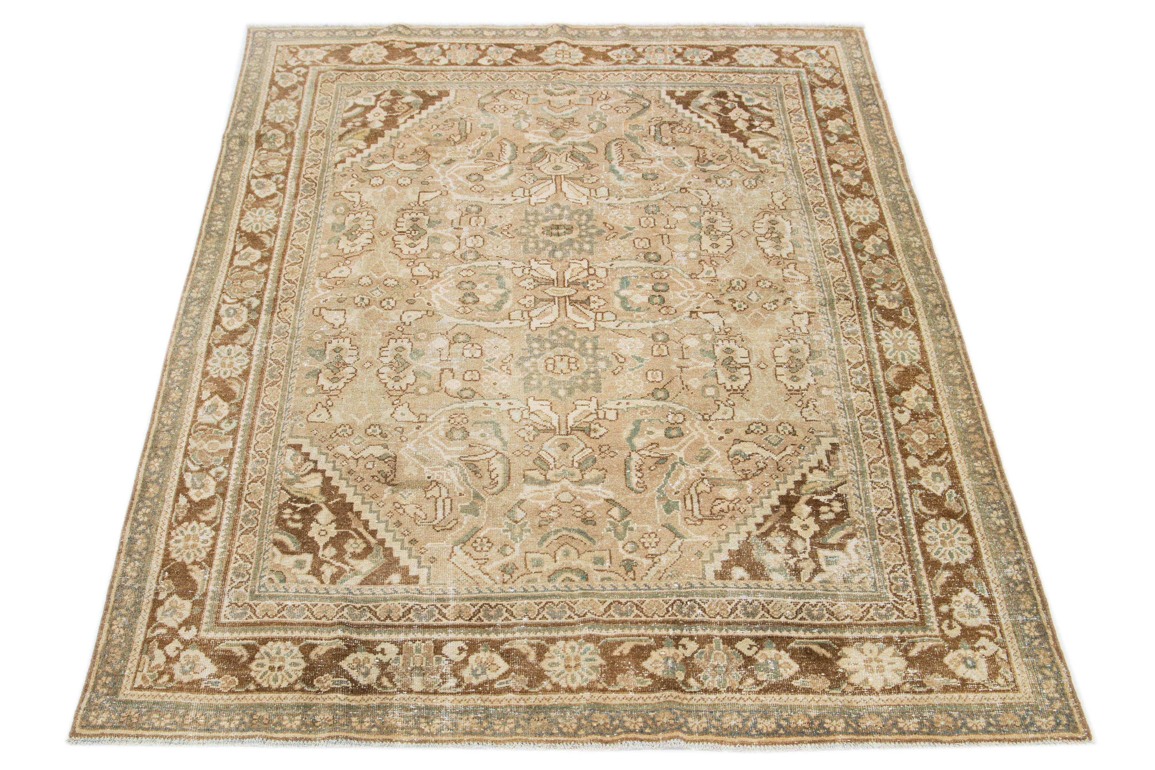 Beautiful Vintage Mahal hand-knotted wool rug with a beige color field. This Persian rug has classic green and brown hues throughout the floral design.

This rug measures 7'2
