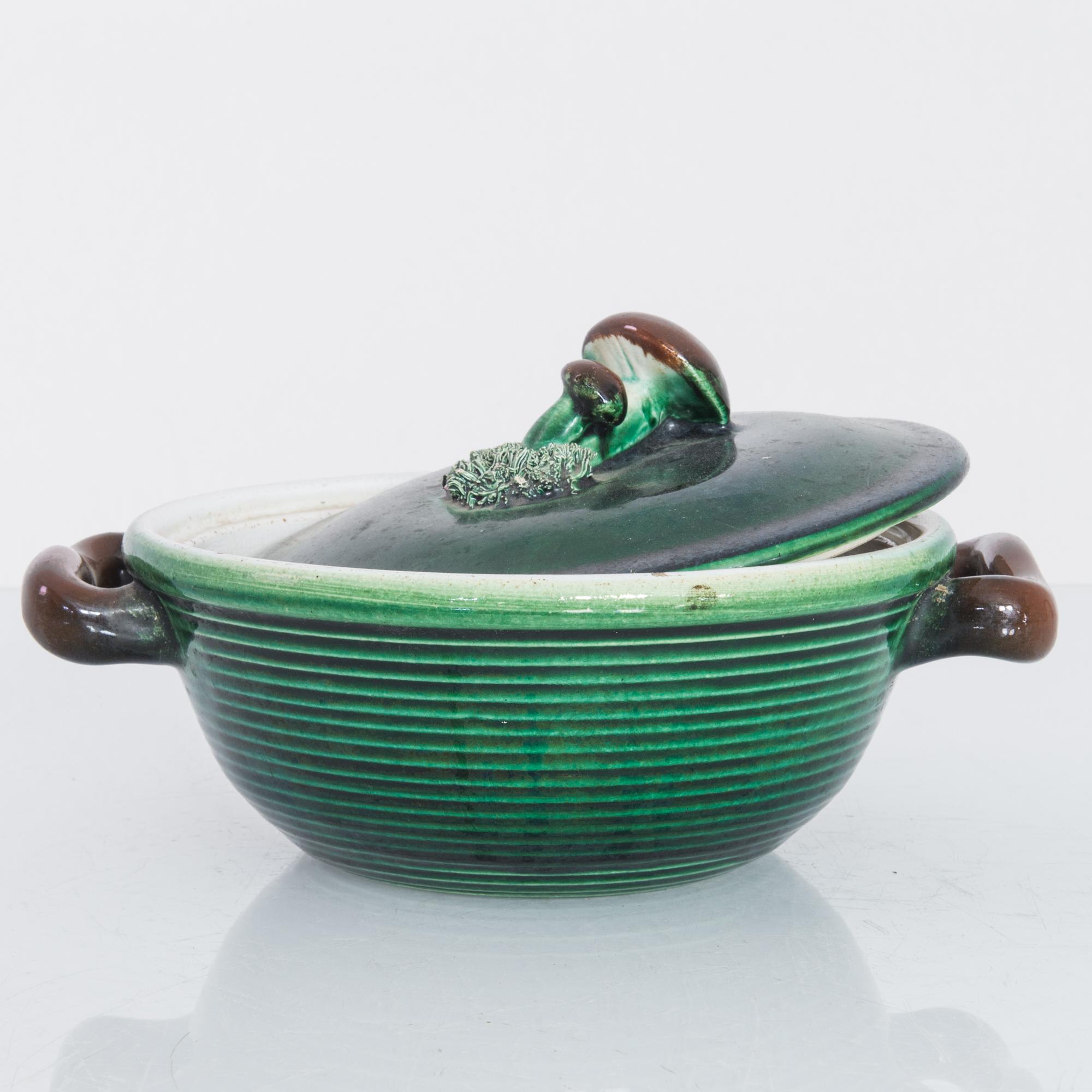 A ceramic bowl with lid from Belgium, circa 1930. A ‘Tellurite’ lidded tureen in rich earth tones of green around the body and brown handles. This piece’s personality stems primarily from the mushroom bunch decoration on the lid, springing forth