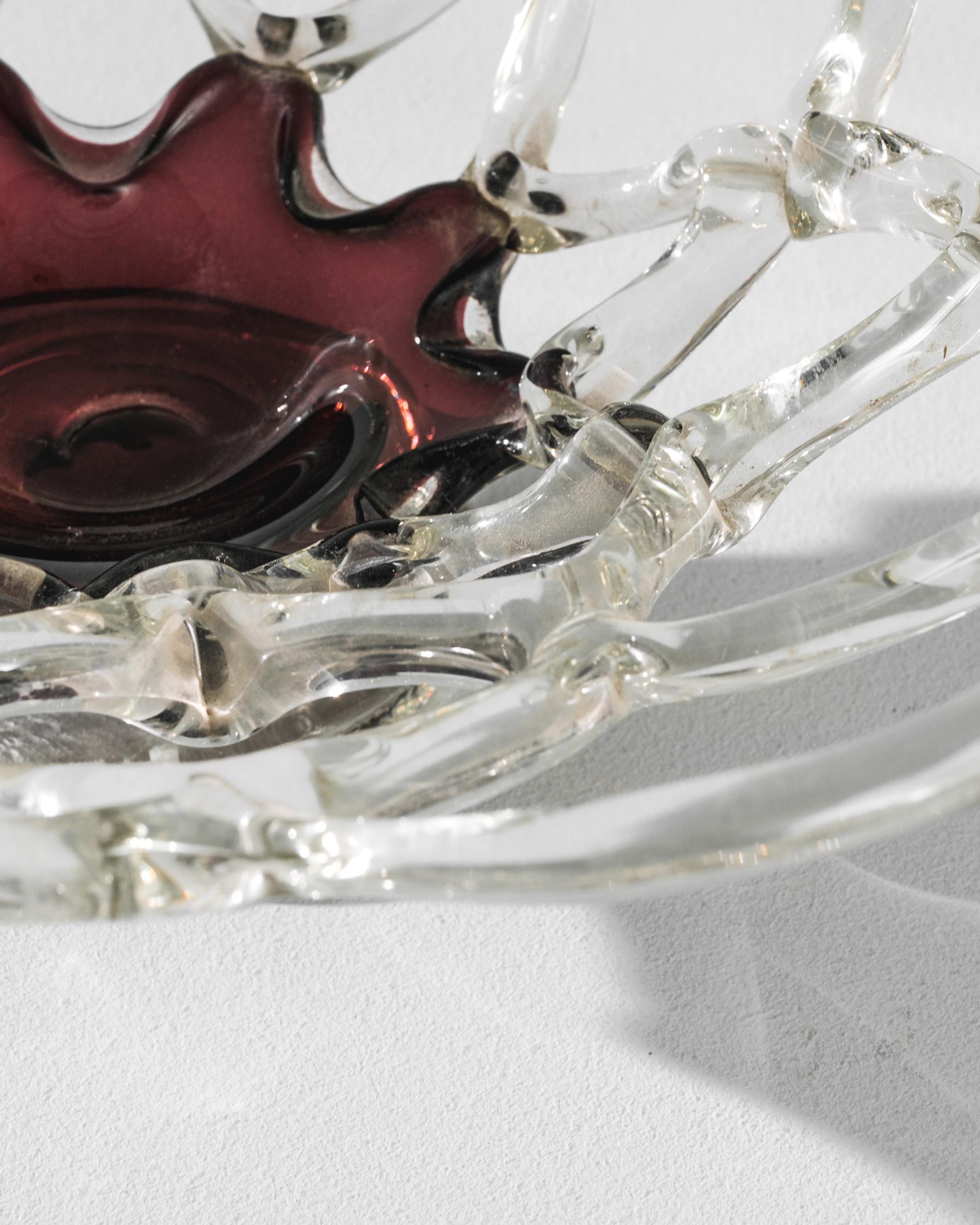 This vintage openwork glass bowl was produced in Belgium, circa 1930. Aerial yet stable, this handblown tour-de-force stands delicately on its base, blooming to reveal a red heart in a raspberry sirup shade. Around its core, the interwoven alveolus