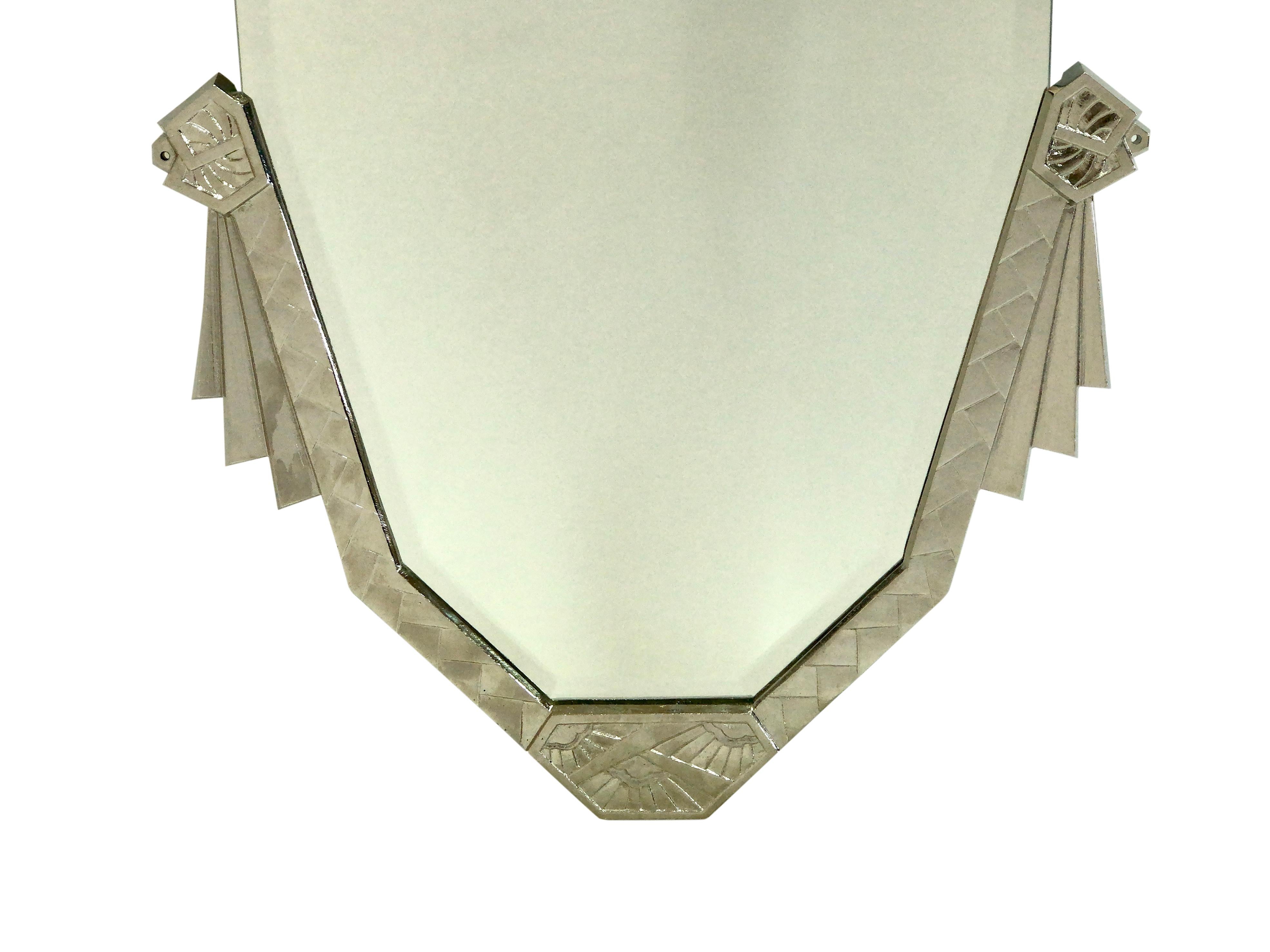 Bevelled mirror. 
Original Art Deco C-shaped bronze frame with Art Deco pattern. 
Surface fresh nickeled 
New bevelled mirror 

Original Art Deco, France, 1930s 

Measurements: 
Width 45 cm 
Height 83.5 cm.