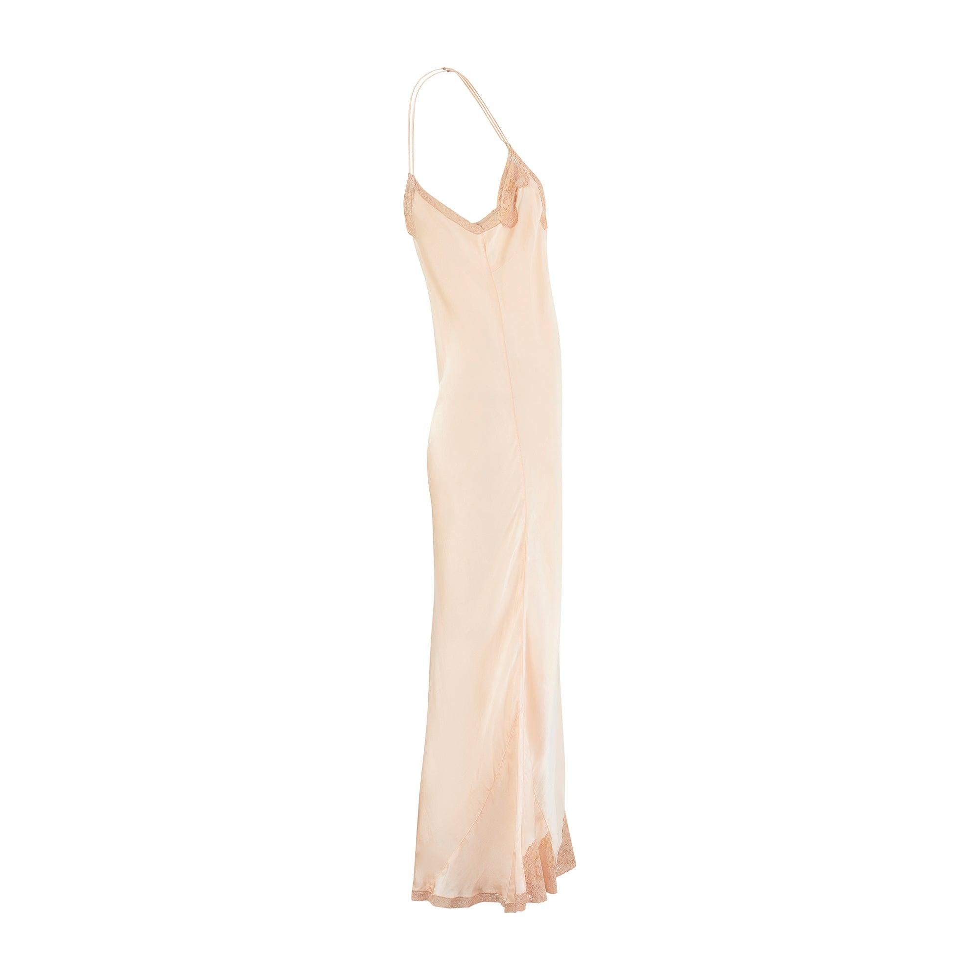 This pretty slip dress was made in the 1930s and displays many signature details of the era’s best lingerie. Tailored from pinky - peach silk with coordinating silk-satin spaghetti straps, it has a nipped-in waist and highly flattering bias cut with