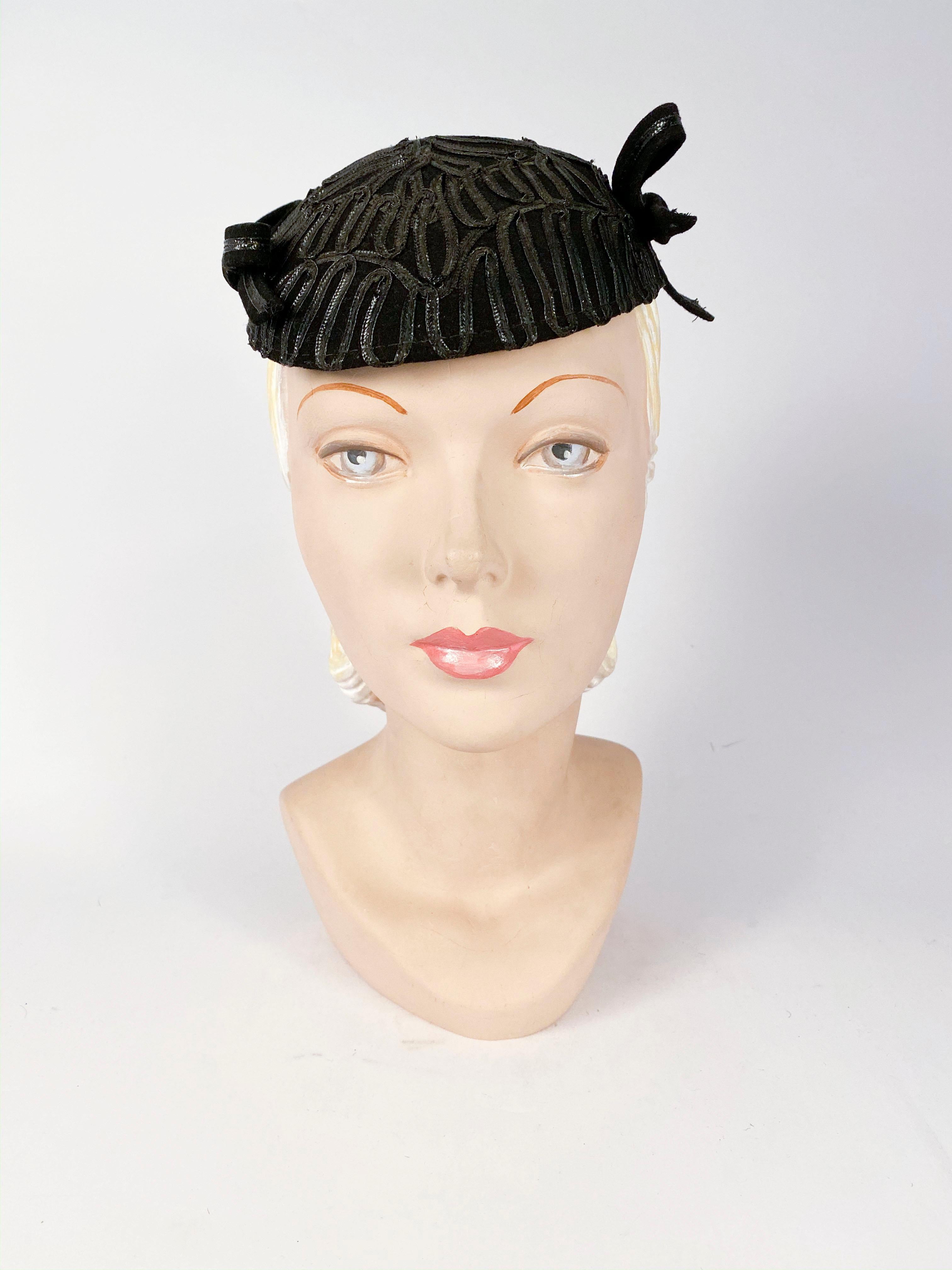 schwarzer Filzhut aus den 1930er Jahren mit schwarzen Raffia-Akzenten am gesamten Hutkörper und zwei Raffia/Filz-Schleifen an den Seiten.