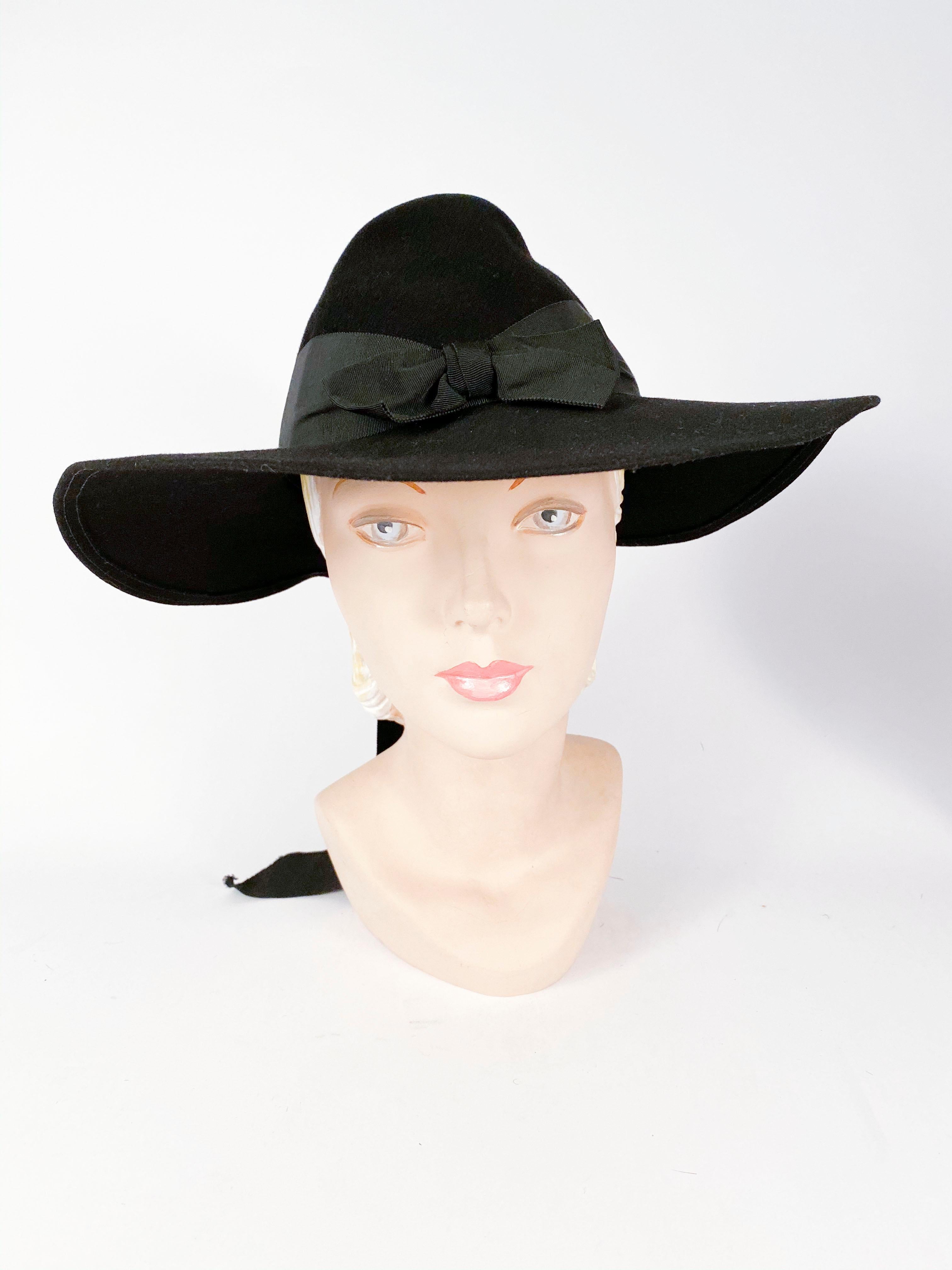 1930s black beaver fur felt wide-brimmed day hat with large bow centered in the front and the back of the hat. Finished with matching wide grow-grain tails.