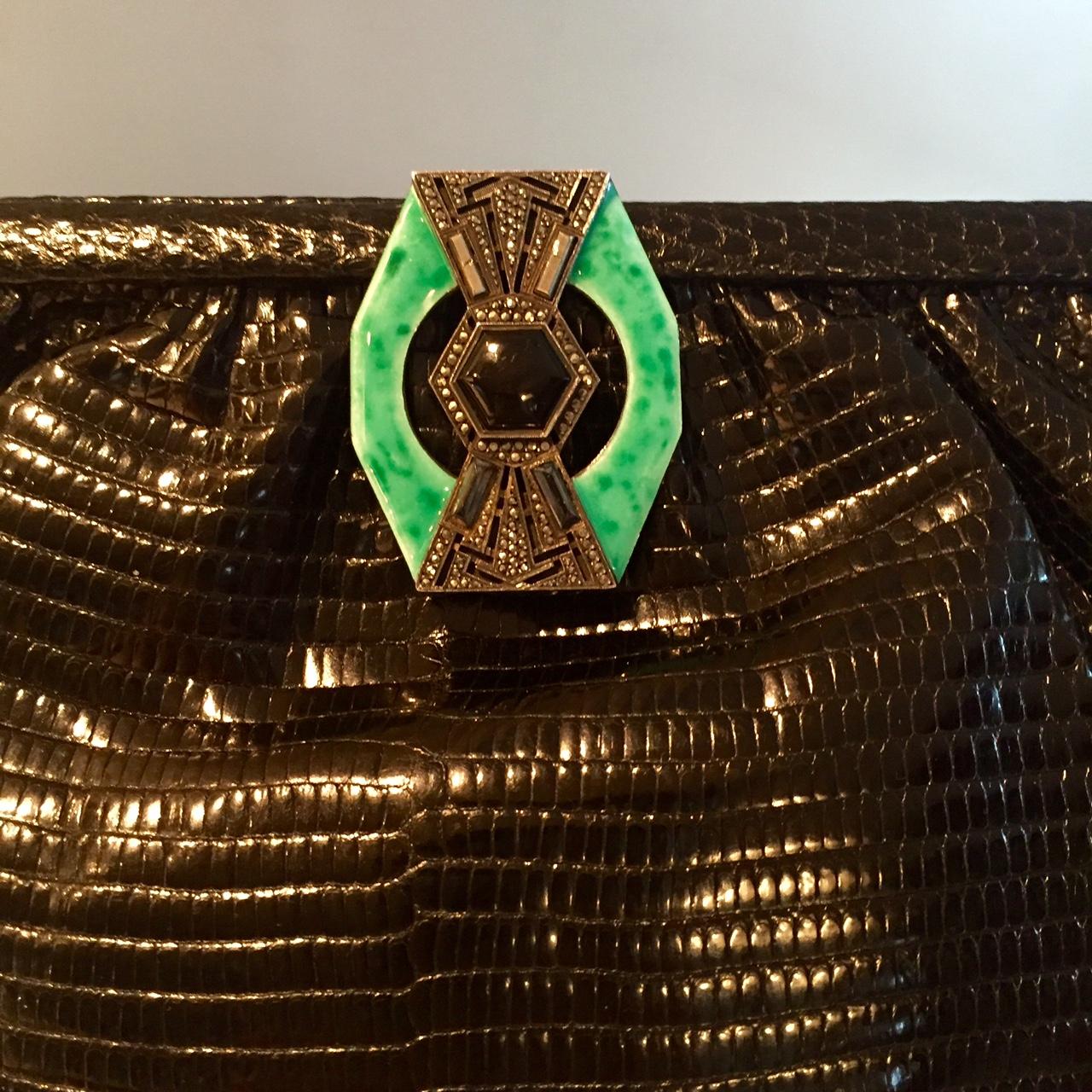 This Art Deco black lizard bag adds a touch of vintage glamour to any outfit. There is an unmarked silver clasp [which I believe is sterling silver ] decorated with marcasites, an onyx stone in the center and bands of chrysoprase on either side.