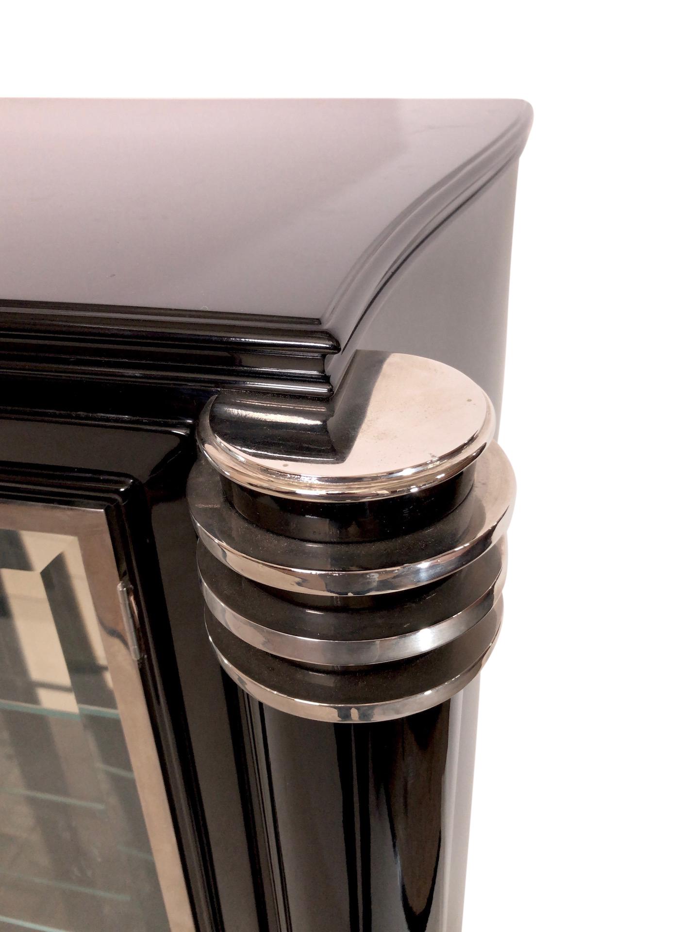 Vitrine and dry bar 
Under the vitrine is a bottle drawer in the middle and to doors on the sides 

High quality restoration:
all metal applications are original and fresh nickeled
Fresh installed mirrors inside the vitrine
Black piano lacquer