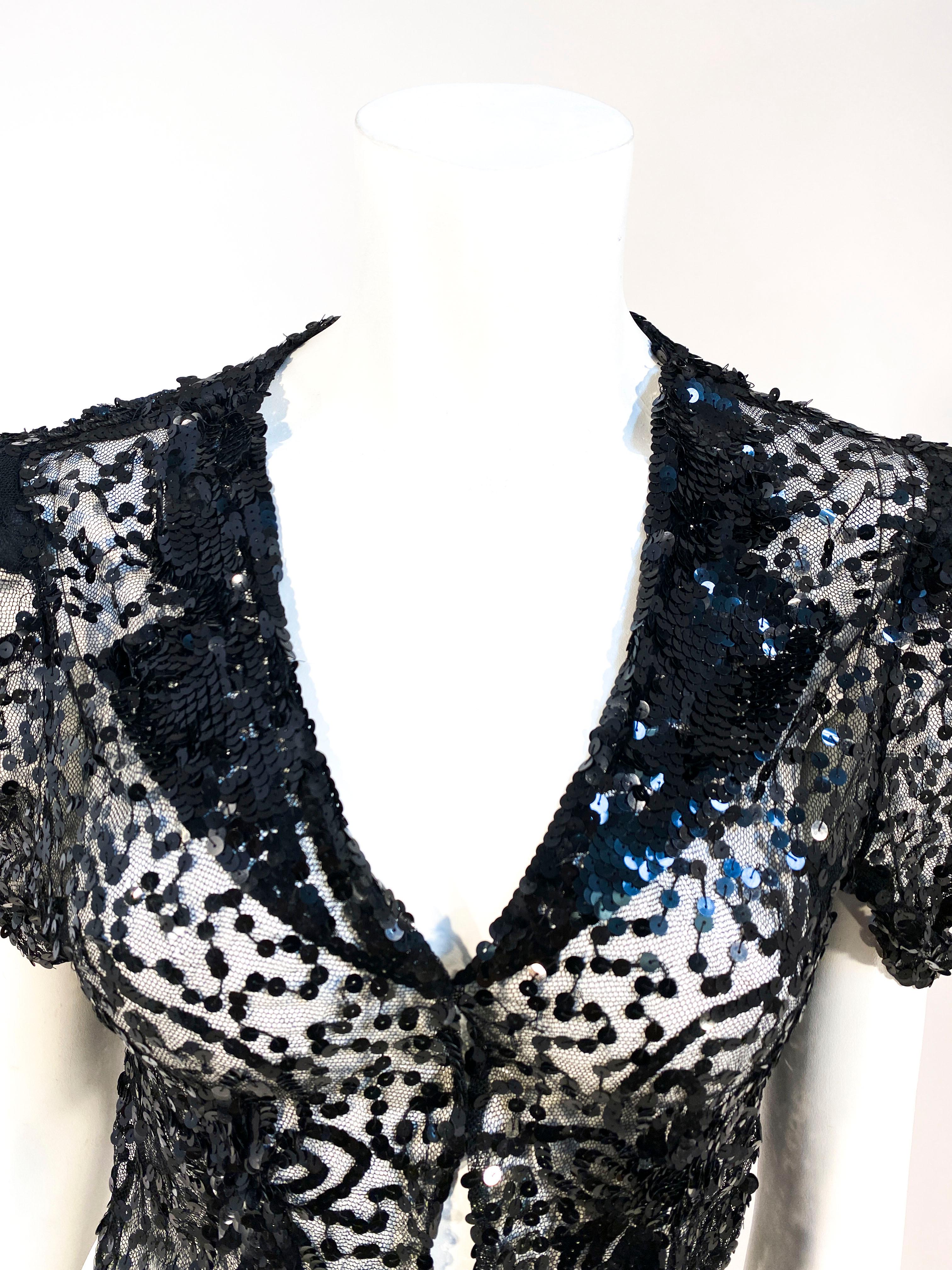 1930s black evening bolero decorated with black sequin in floral patters and an enlarged faux tux-like lapel. The shoulders are padded to creates a short but full sleeve. There is a hook and eye closure in the front but this piece could be worn open