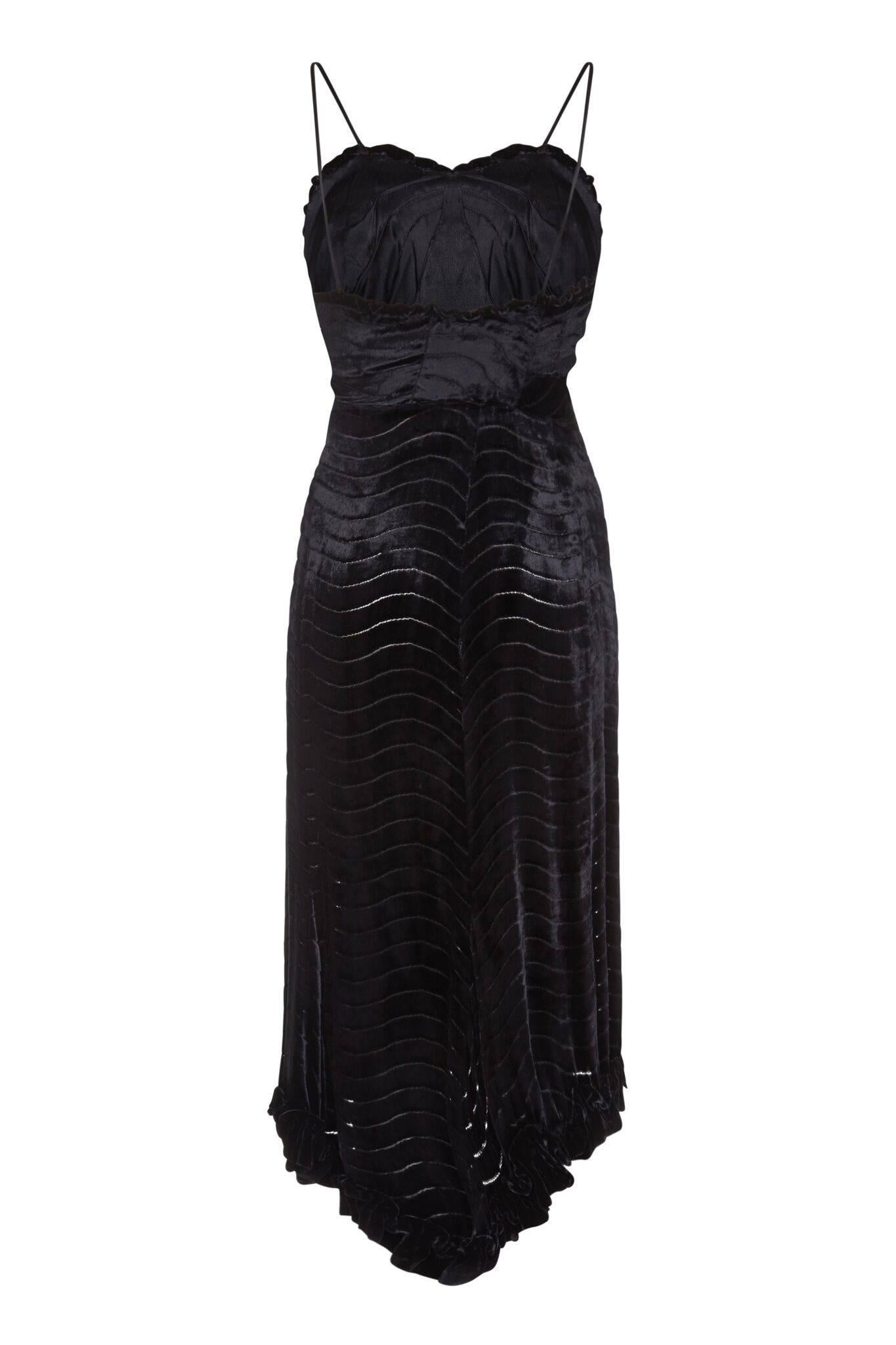 This exquisite vintage 1930s black silk devore velvet evening dress is delicate and gamine with intricate tailoring and construction. The fine velvet fabric has a gentle linear wave pattern, which the designer has used to create structure in the