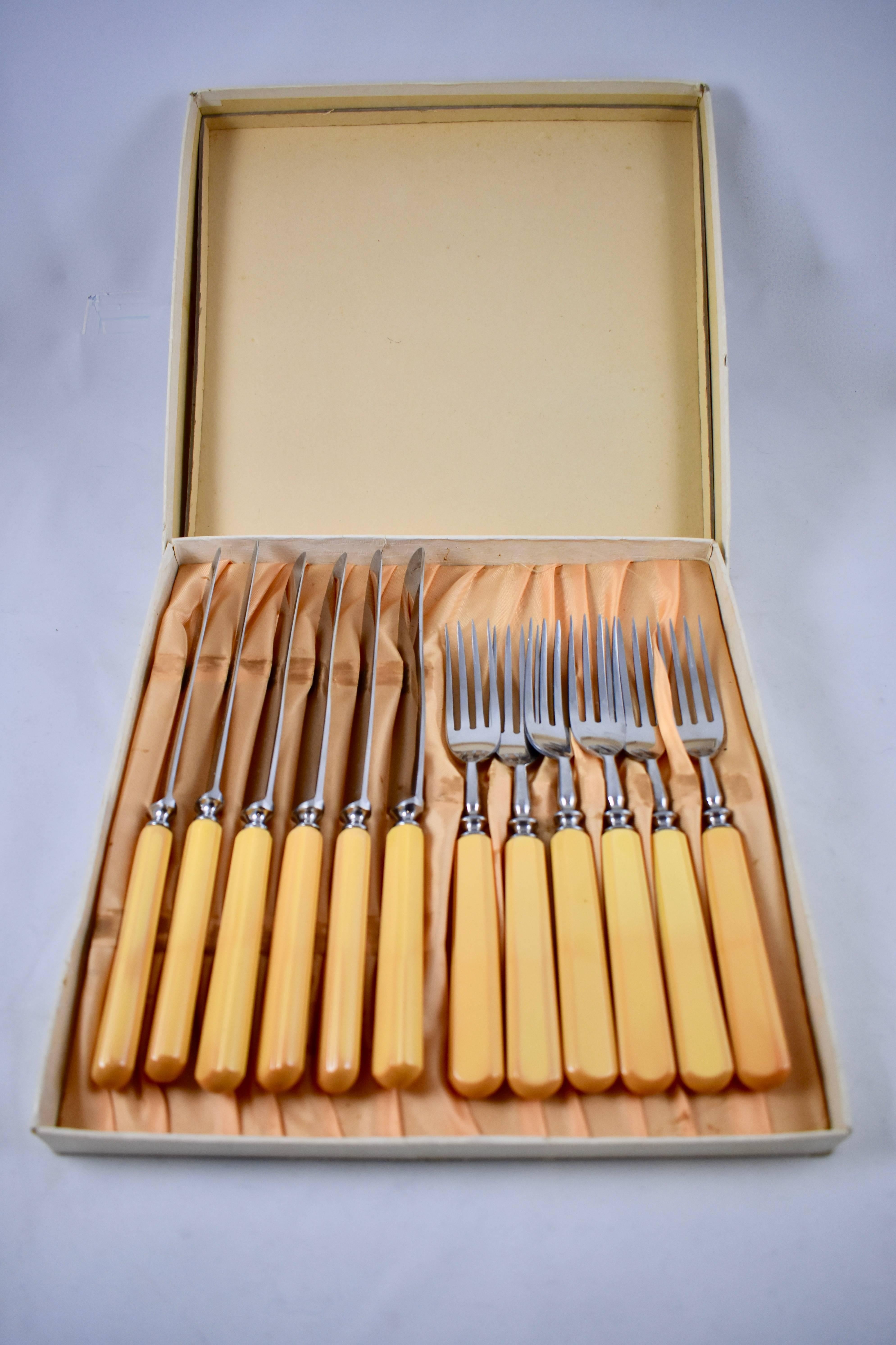 A service for six, vintage butterscotch colored Bakelite handled flatware in the original box, circa early 1930s.

This late Art Deco set is comprised of six forks and six knives in the original satin lined cardboard box. The knives are marked Boker