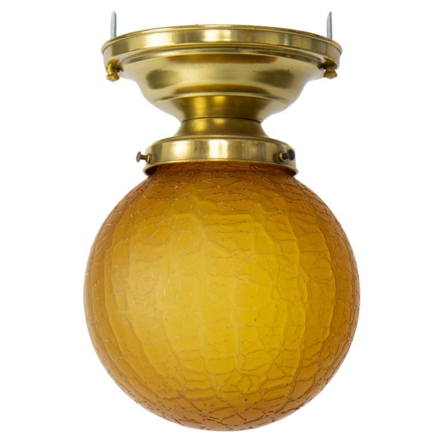 1930’s Brass Flush Mount Fixture with Amber Crackle Glass For Sale