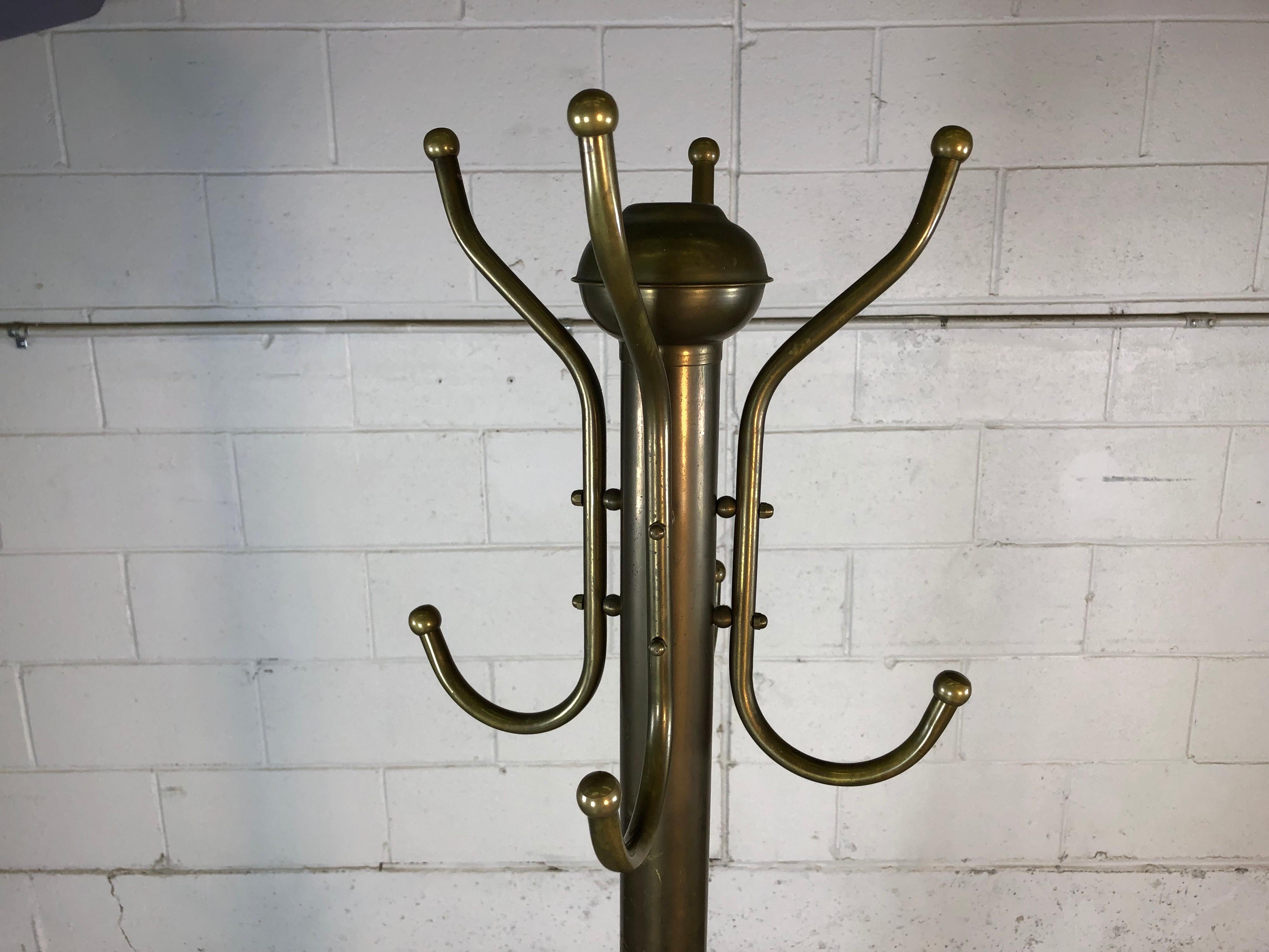 Vintage 1930s tall brass Art Deco coat rack with a round base and twelve total hooks. Original patina.
   