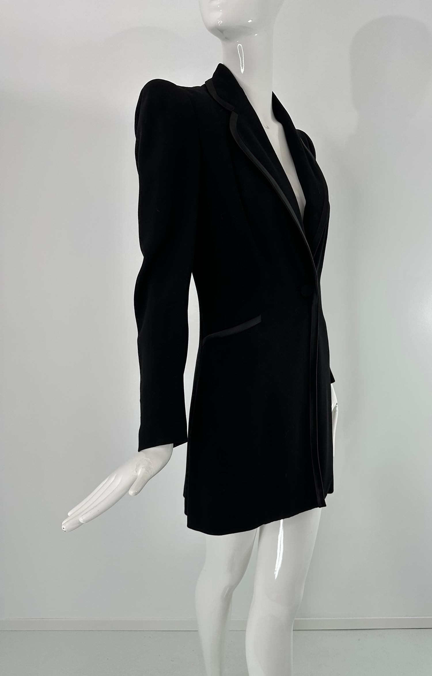 1930s Brenner Bros., New York black wool blend twill, tuxedo style coat. Single breasted coat with a single button at the waist closure. Peaked shoulders, long sleeves. The coat skims the body and is approximately knee length, depending on your