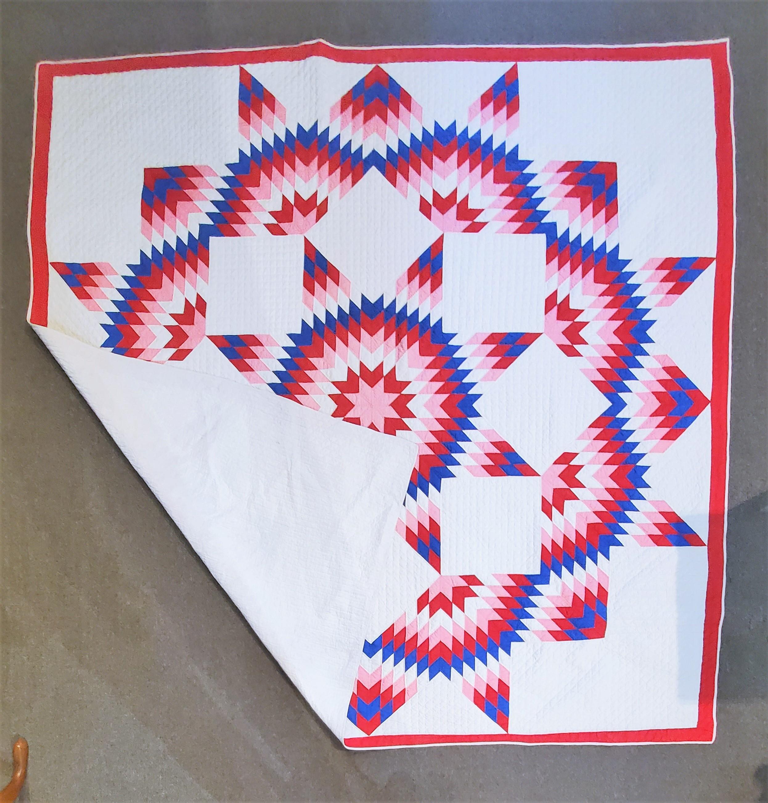 This finely quilted and pieced broken star quilt is in fine condition. It’s most unusual with the pink trailing color. Really works well with the red, white and blue colors.