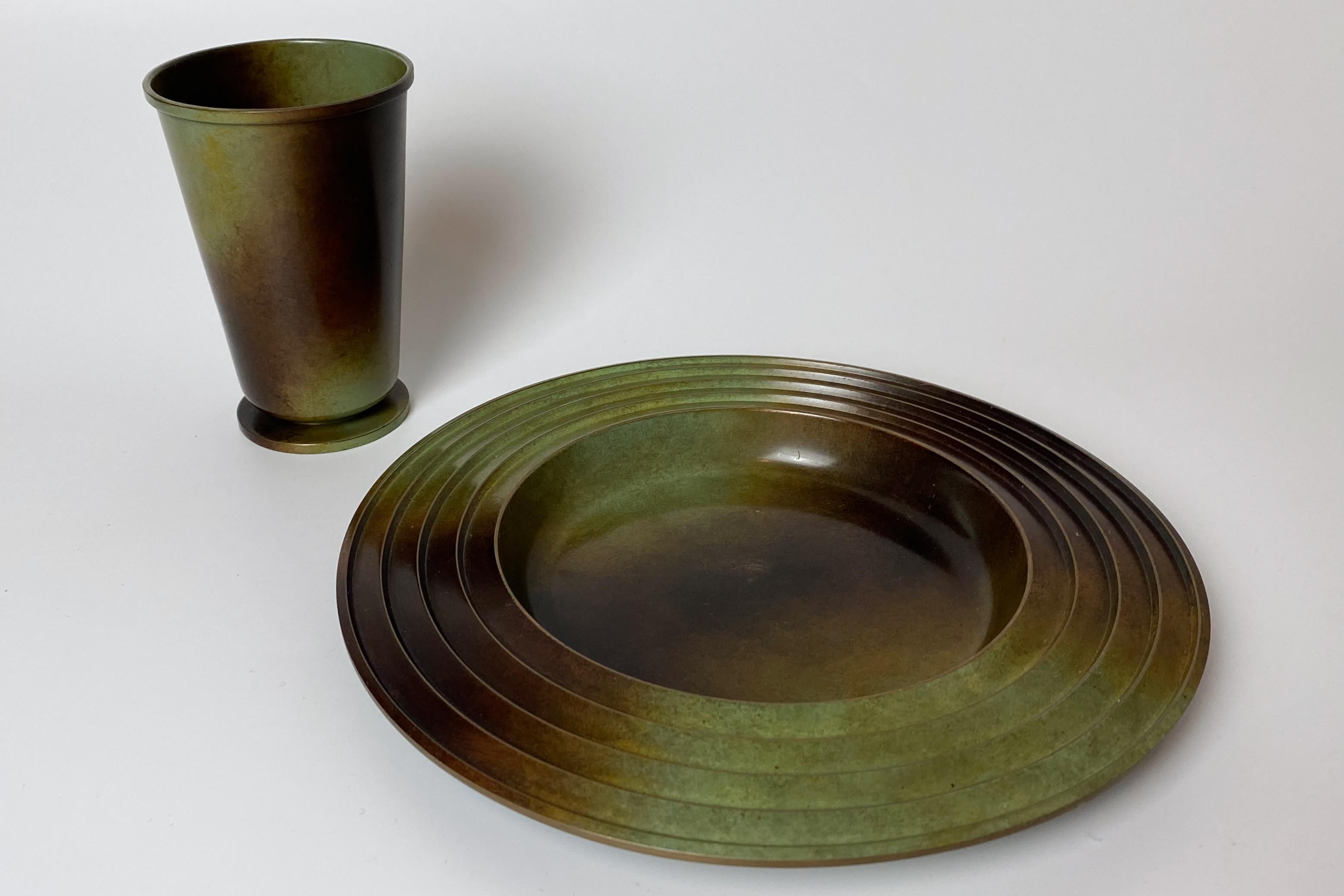 Schönes Set aus einem Teller und einer Vase aus patinierter Bronze von Ystad Brons, Schweden, aus den 1930er Jahren. Der Teller wurde von Ivar Ålenius-Björk entworfen. Sehr guter Zustand mit kleinen Gebrauchsspuren.

Land: Schweden

Hersteller: