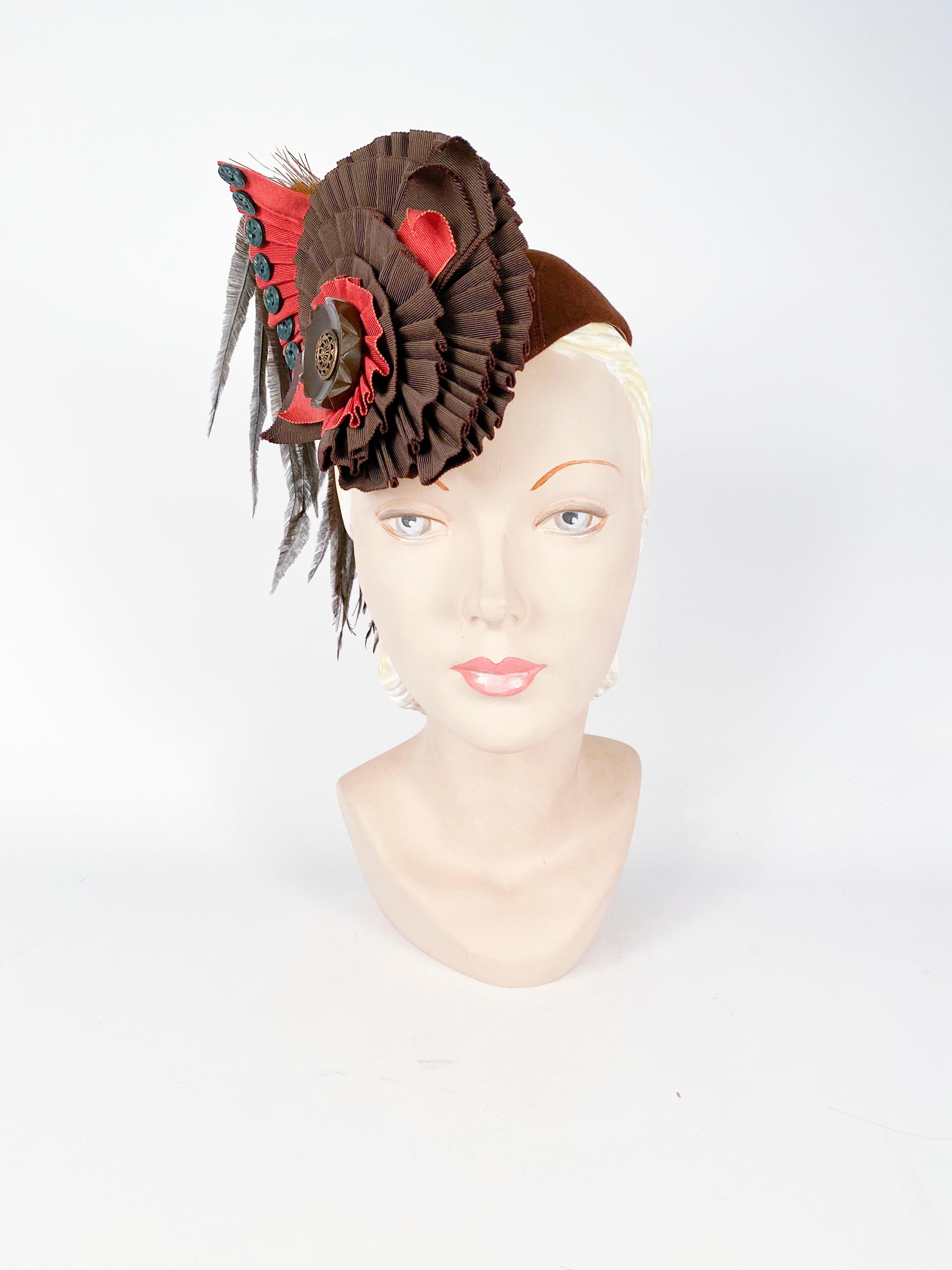 1930s Brown beaver fur felt hat with rust-colored and chocolate brown structured ruffled ribbon accent centered with a large bakelite button finished with hand-curled feathers. 