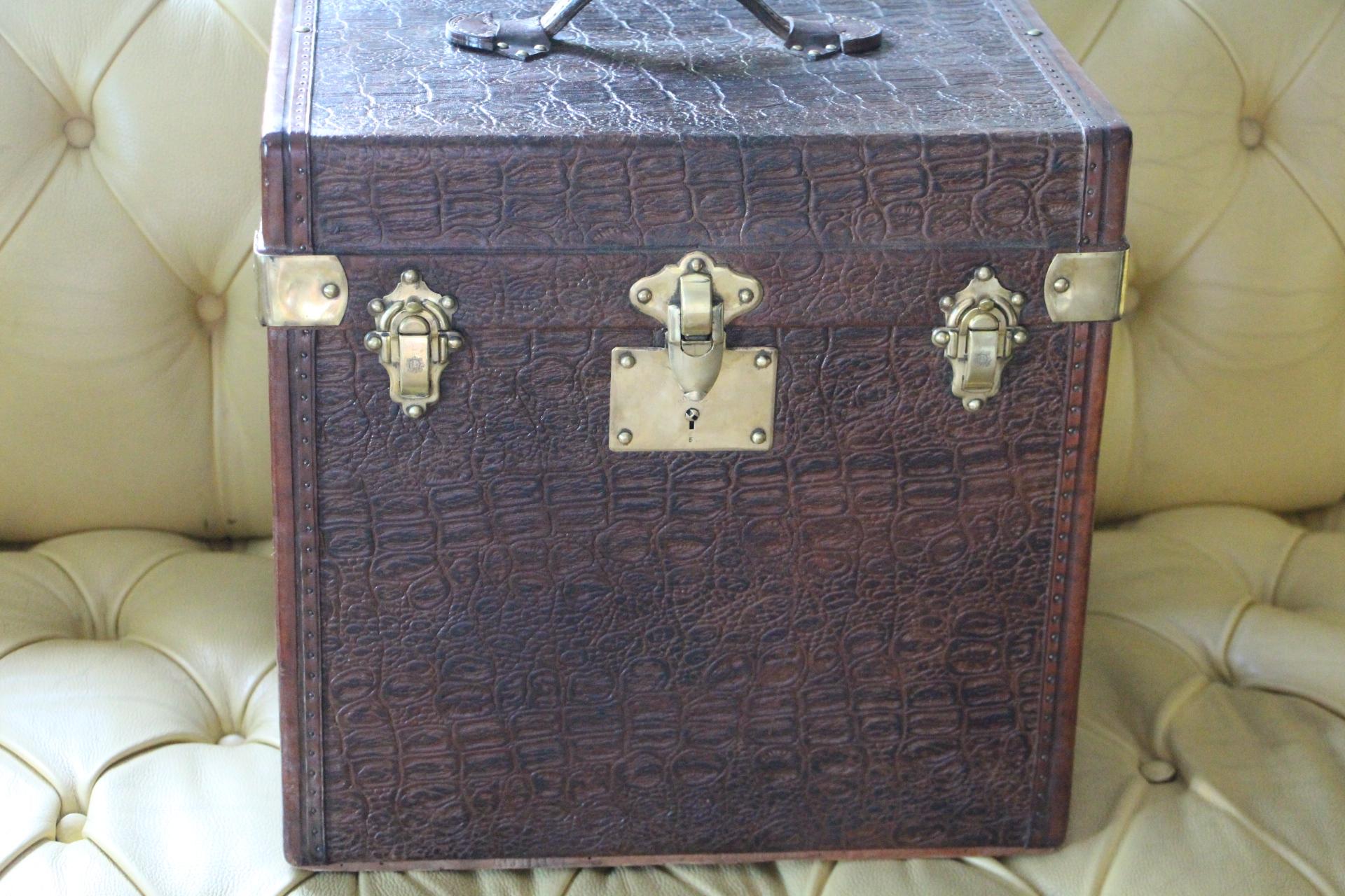 This very nice brown canvas and leather hat box features leather trim and leather top handle as well as solid brass locks and studs.Its canvas looks like crocodile skin.
It is very elegant and it has got a very rich and warm patina.
Its interior
