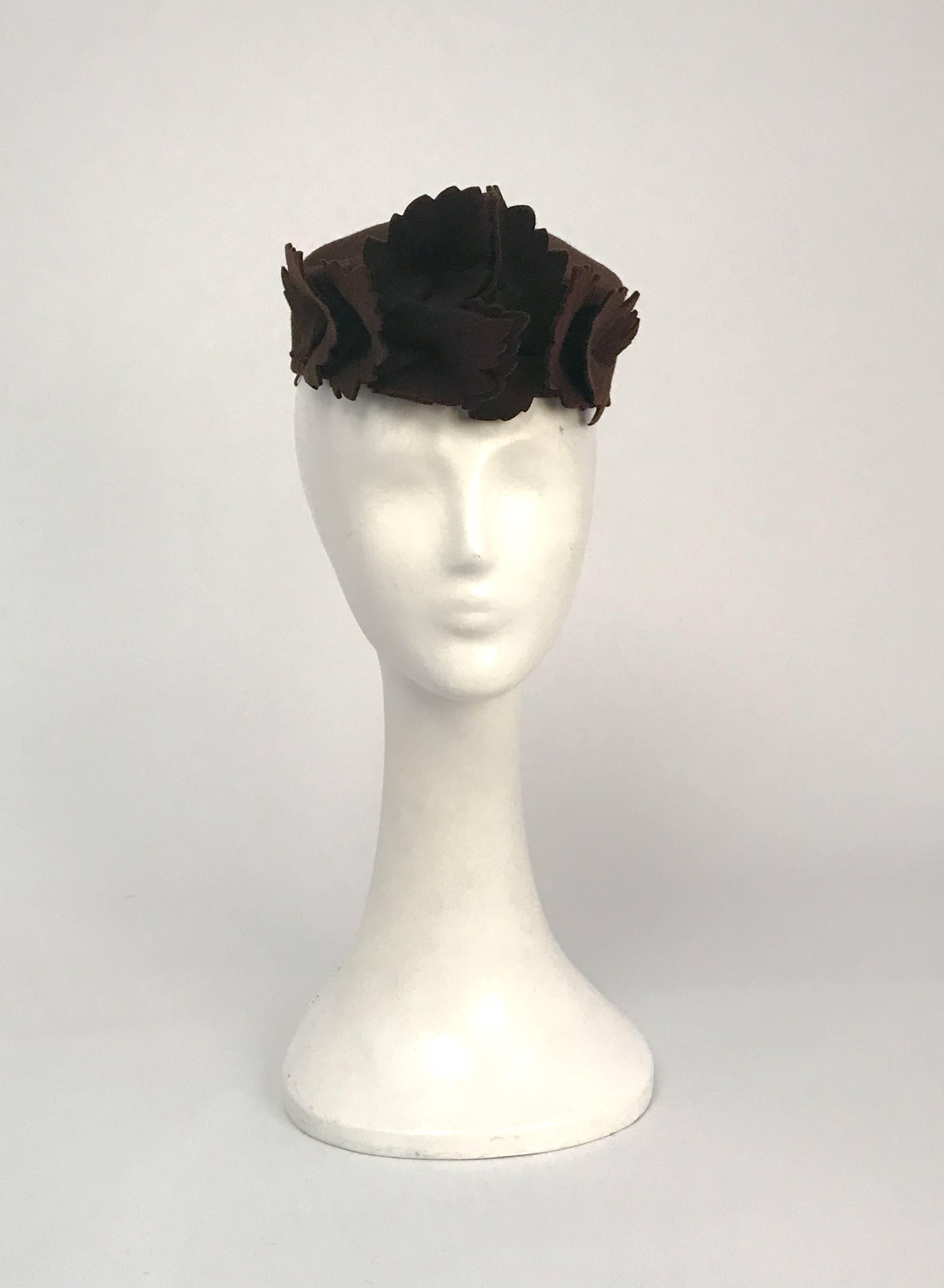 chapeau en laine orné de feuilles marron des années 1930. Chapeau en feutre brun avec des embellissements de feuilles brunes. Bande élastique pour fixer le chapeau sur la tête. circonférence de 22 pouces.