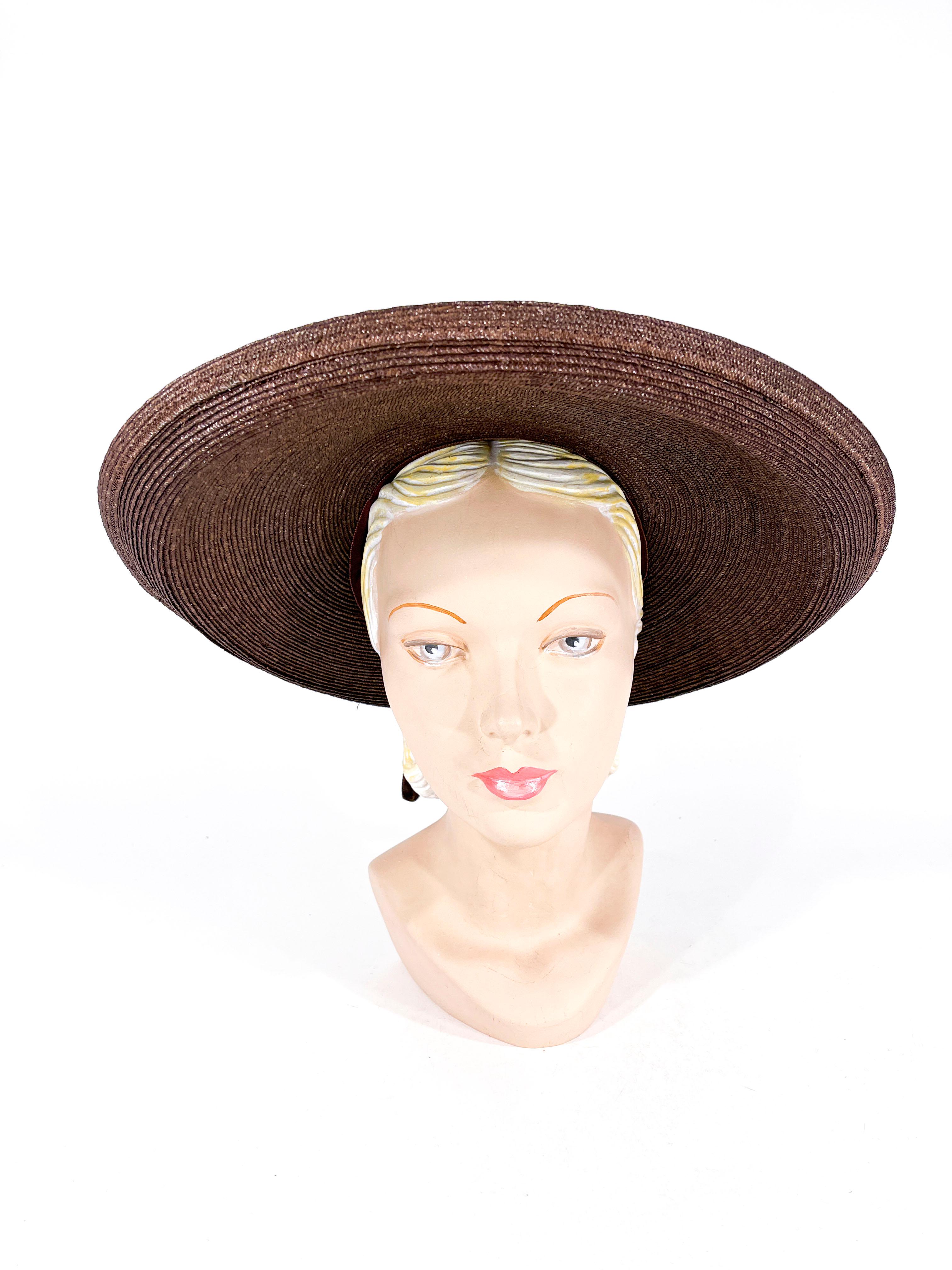 1930s cocoa brown woven straw picture sun hat with a rolled hatband of straw and velvet ribbon finished with a bow and drape on the back. The wide brim is turned up along the edges. The interior of the crown is unlined and finished with a grosgrain