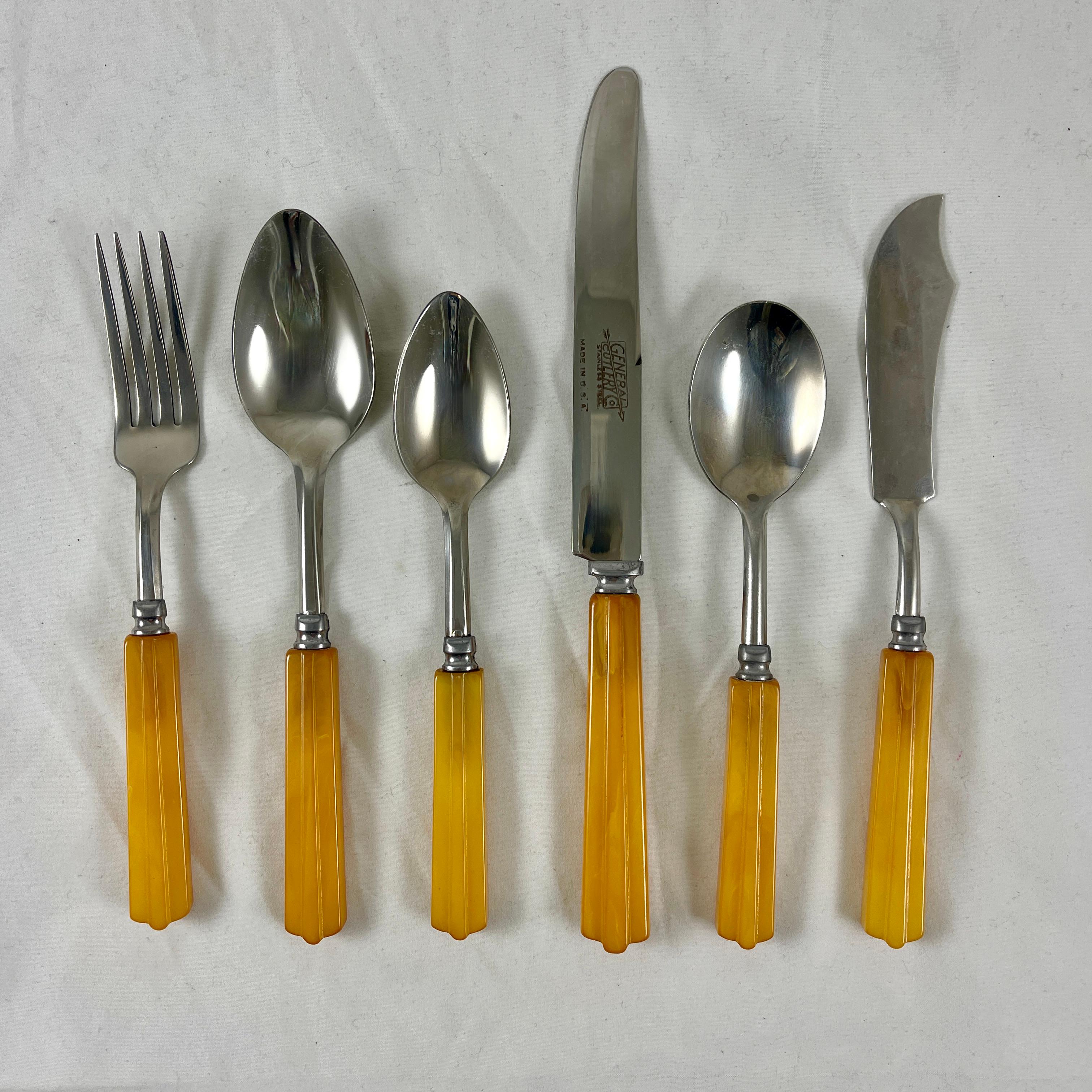 A full 26 piece set of Butterscotch Bakelite and stainless steel flatware set in the Art Deco style, made by General Cutlery Co. USA – circa early 1930s.

Six each knives, forks, soup spoons, and tea spoons, along with a spreader and serving spoon.