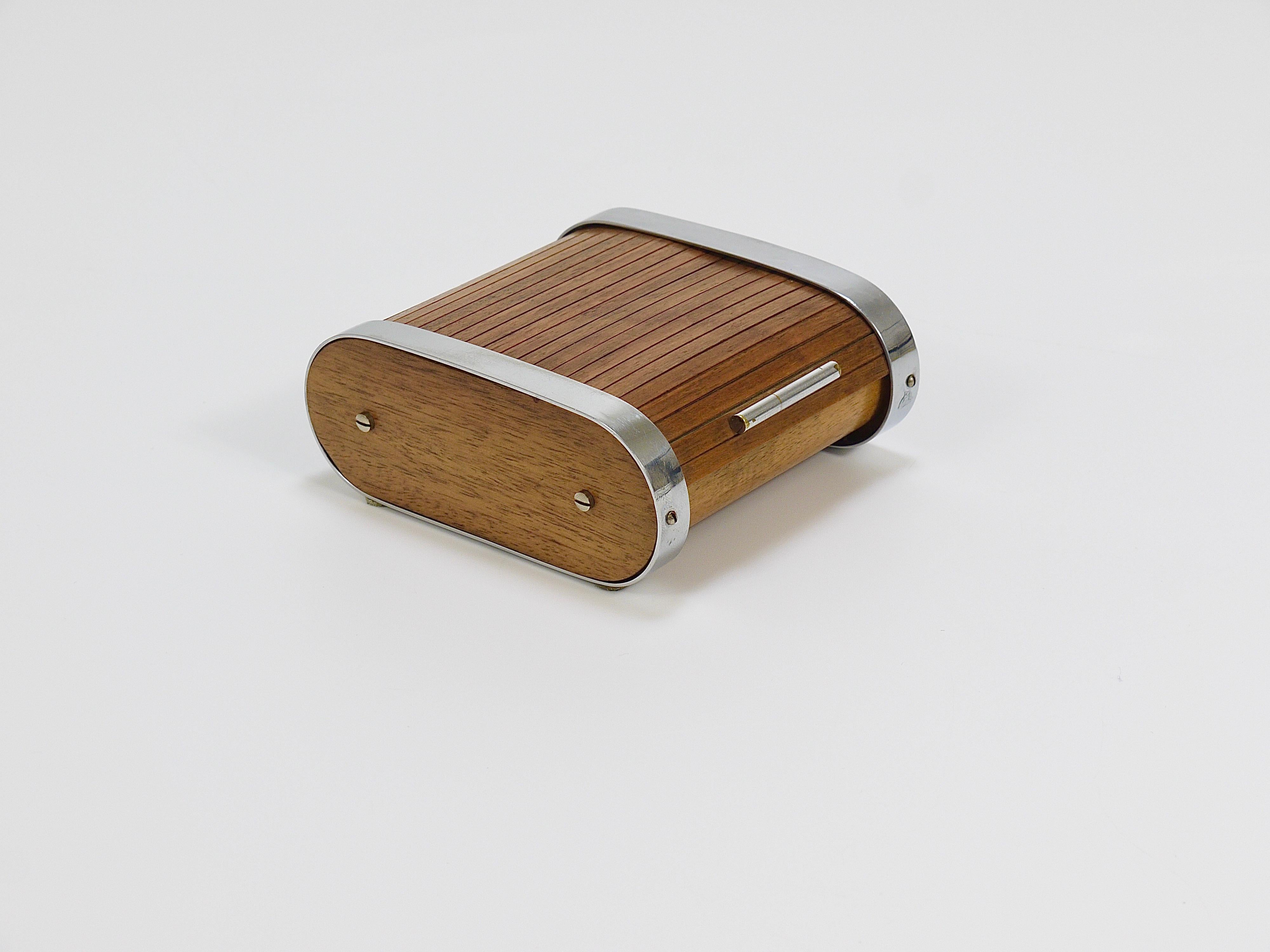 Rare boîte de rangement ou distributeur de cigarettes à couvercle déroulant datant des années 1930. Il s'agit d'un des premiers modèles de Carl Aubock I+I. Fabriqué à la main en bois de noyer et en laiton nickelé. En bon état.