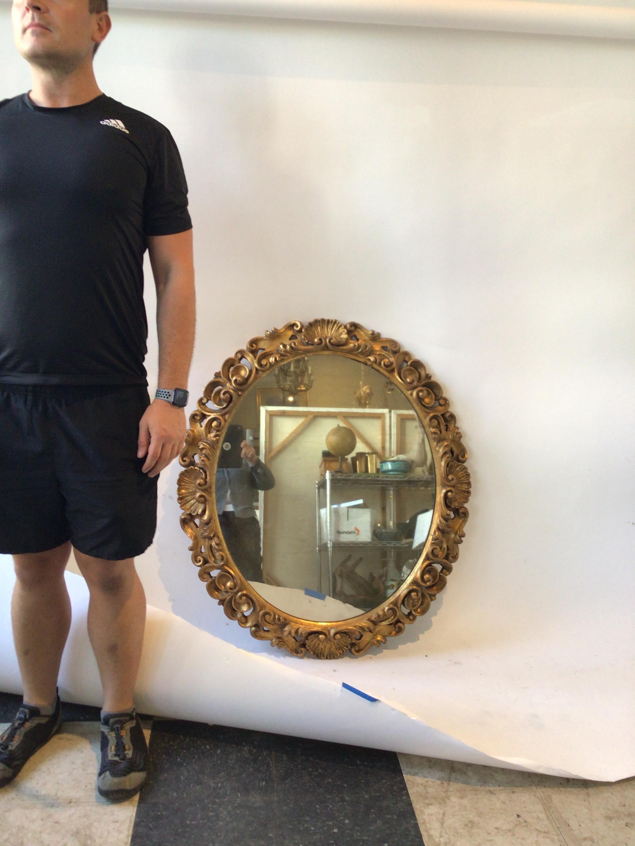 Mid-20th Century 1930s Carved Wood Gilt Oval Italian Mirror with Shell Motif For Sale