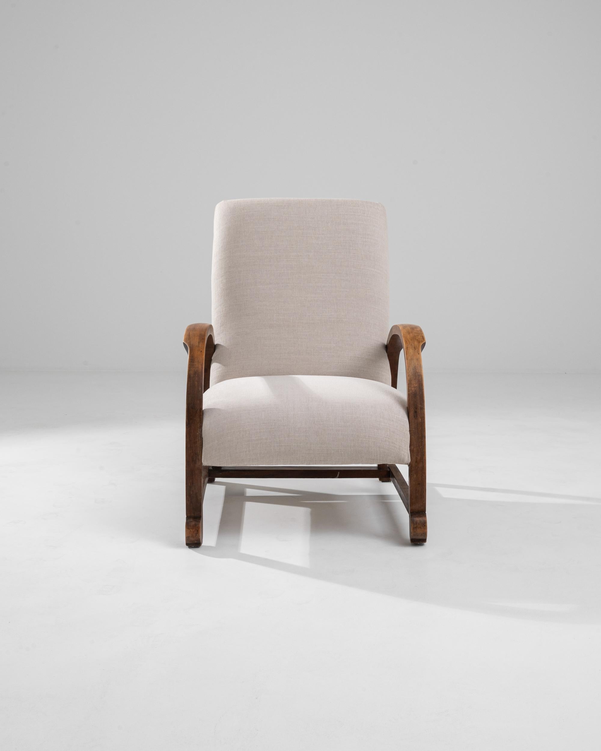 Striking and sophisticated, this vintage armchair offers a unique period piece. Made in Central Europe in the 1930s, the design takes inspiration from the elegant geometries of Vienna Secession furniture. The upholstered seat is framed between a