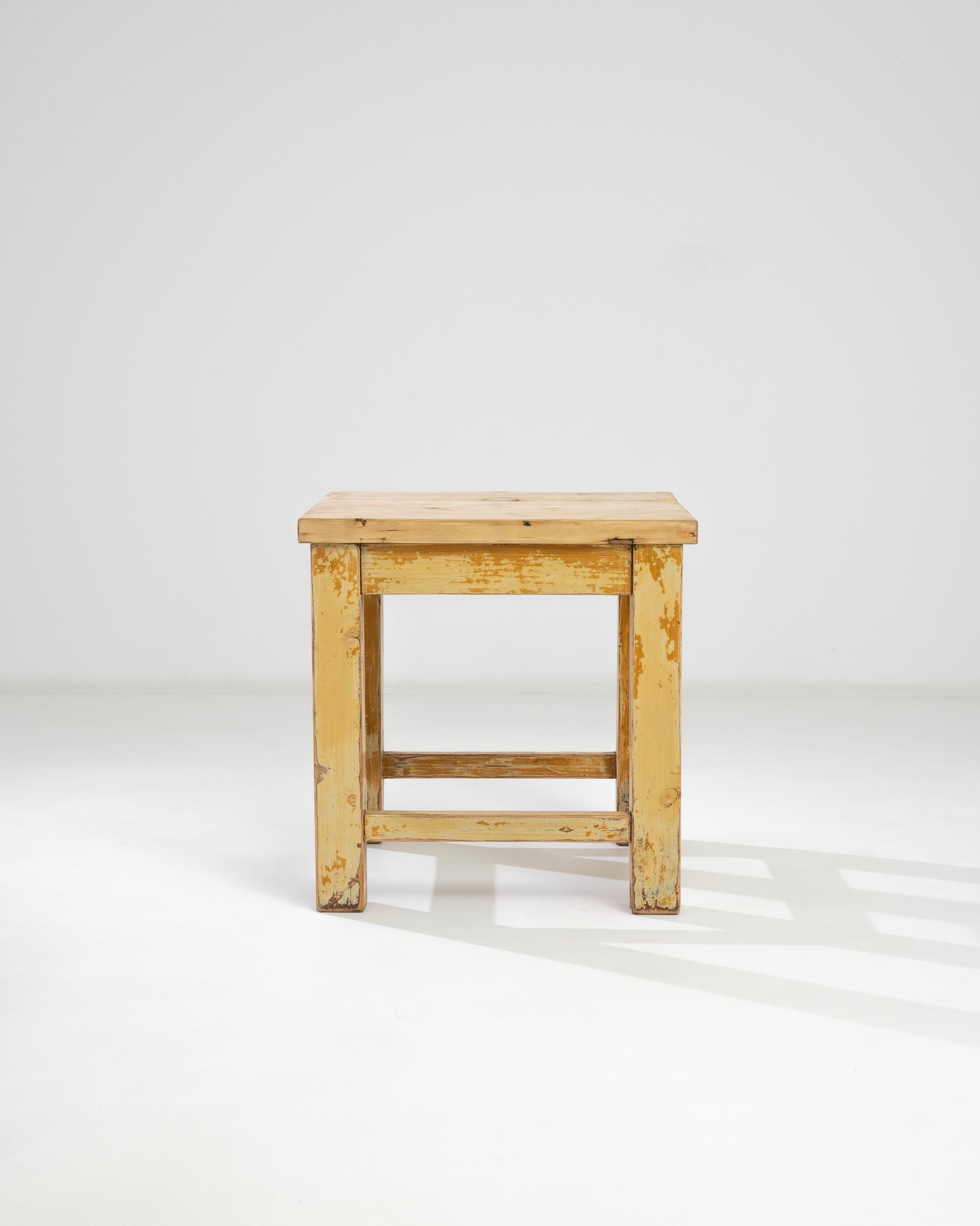 A wooden side table from 1930s central Europe. Constructed nearly in the dimensions of a cube, this solidly constructed table catches the eye as a charming and bright furnishing addition. Mortise and tenon aprons and stretchers fit together smartly,