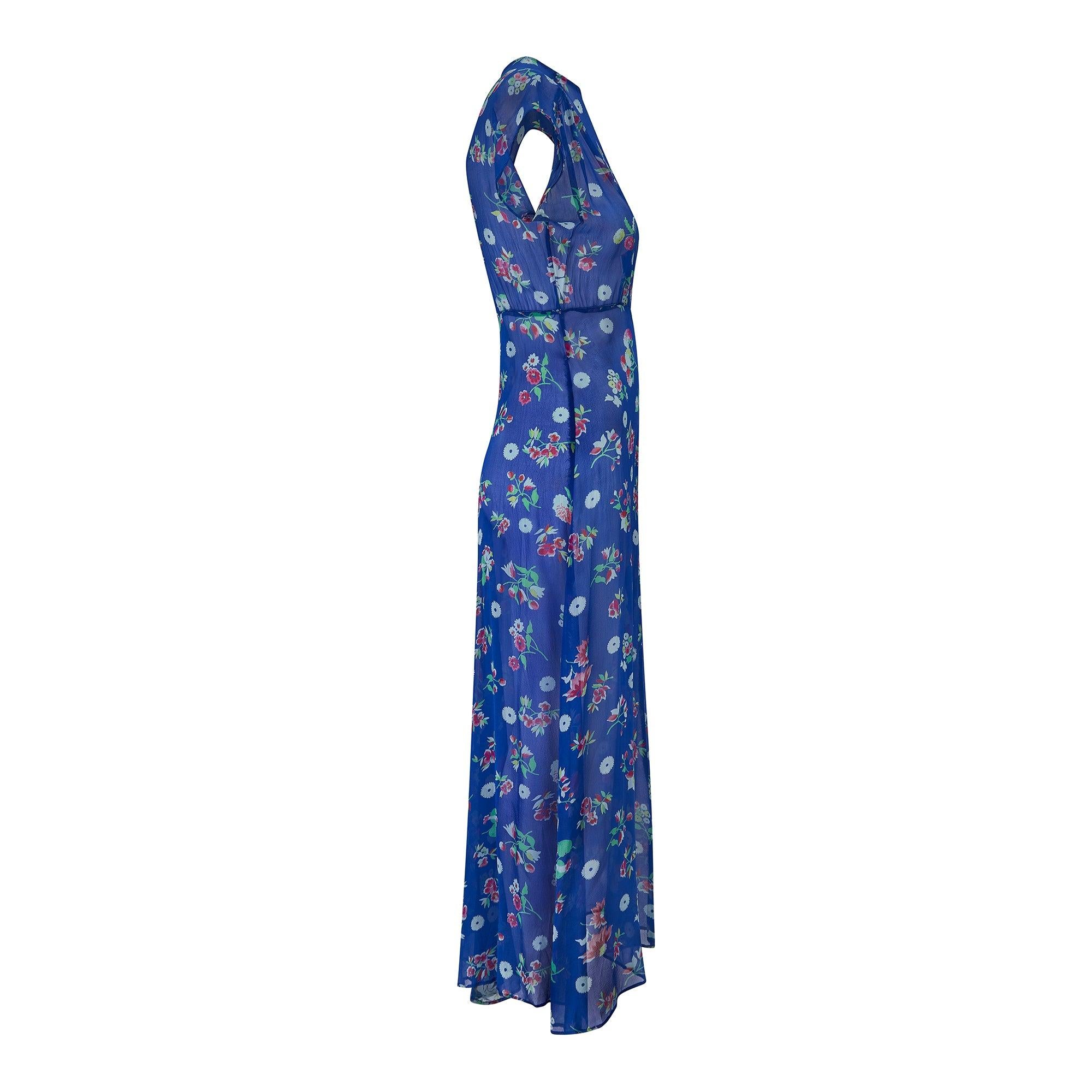 This 1930s ankle length dress is cut to a classic tea dress style in cobalt blue chiffon with striking fuchsia, pale blue, yellow and pistachio green florals dotted across it. Full of character with lovely period details; it has a keyhole cut out at