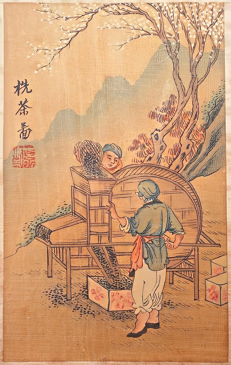 Detailed hand painted Chinese picture on silk, featuring two Chinese workers processing tea leaves, with a white blossom tree and mountain background. It has a bamboo surround frame, and is mounted on a plywood back. The raised bamboo frame gives an
