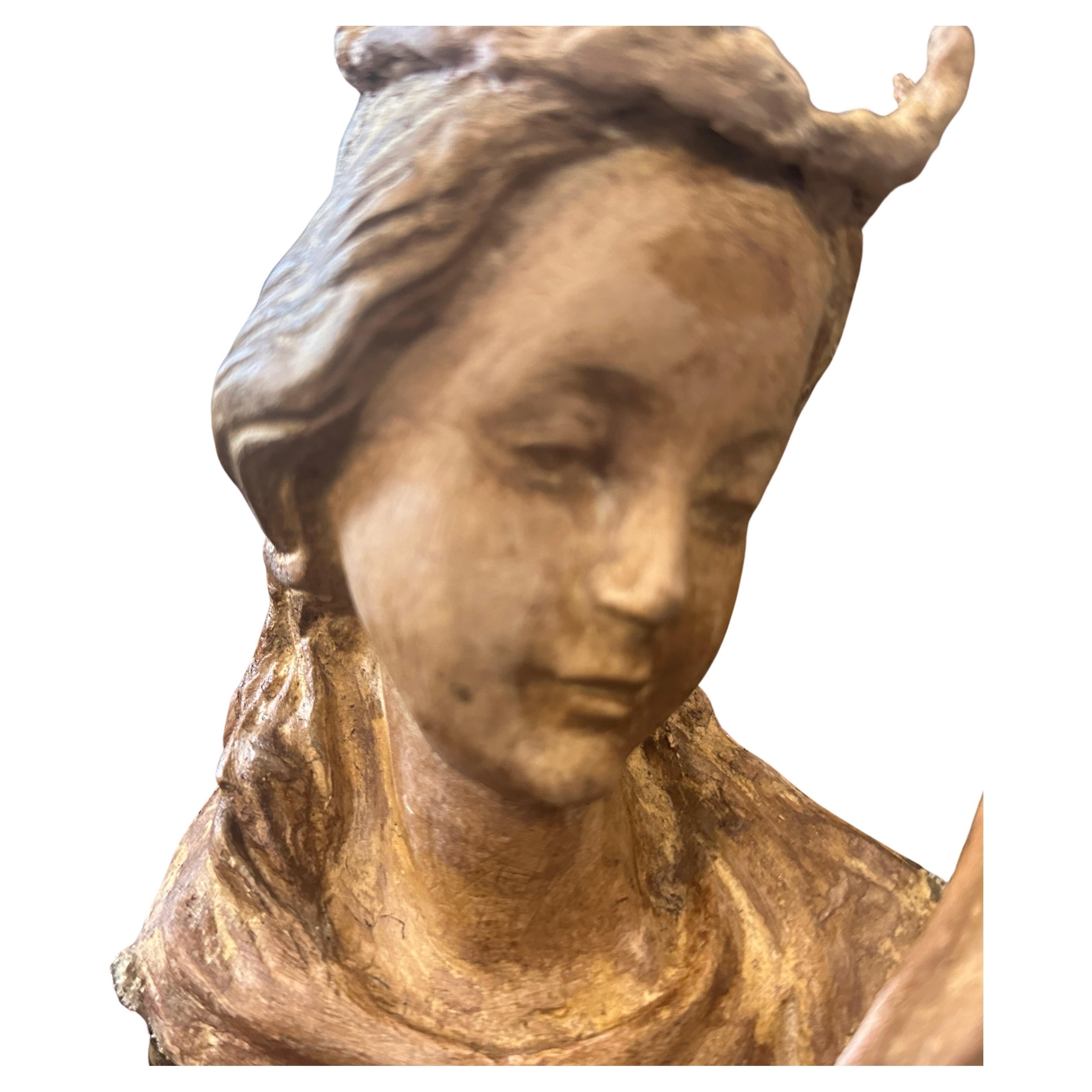 A papier mâché sculpture of Saint Agata hand-crafted in Sicily in the first half of 20th century, the item is mounted on a round glass and wood display case. St. Agata is a prominent figure in Sicilian religious tradition. Understanding the
