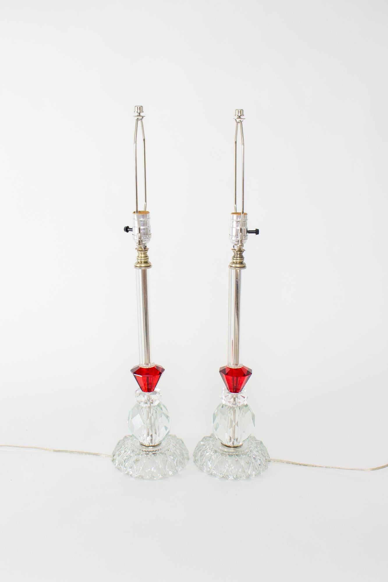 1930's clear and red glass table lamps - a pair. Cut glass base and ball. Conical shaped red glass piece, and then a slender clear tube leading up to the socket. These would be fantastic on a sideboard or on a bedside table. Art Deco. American, C.