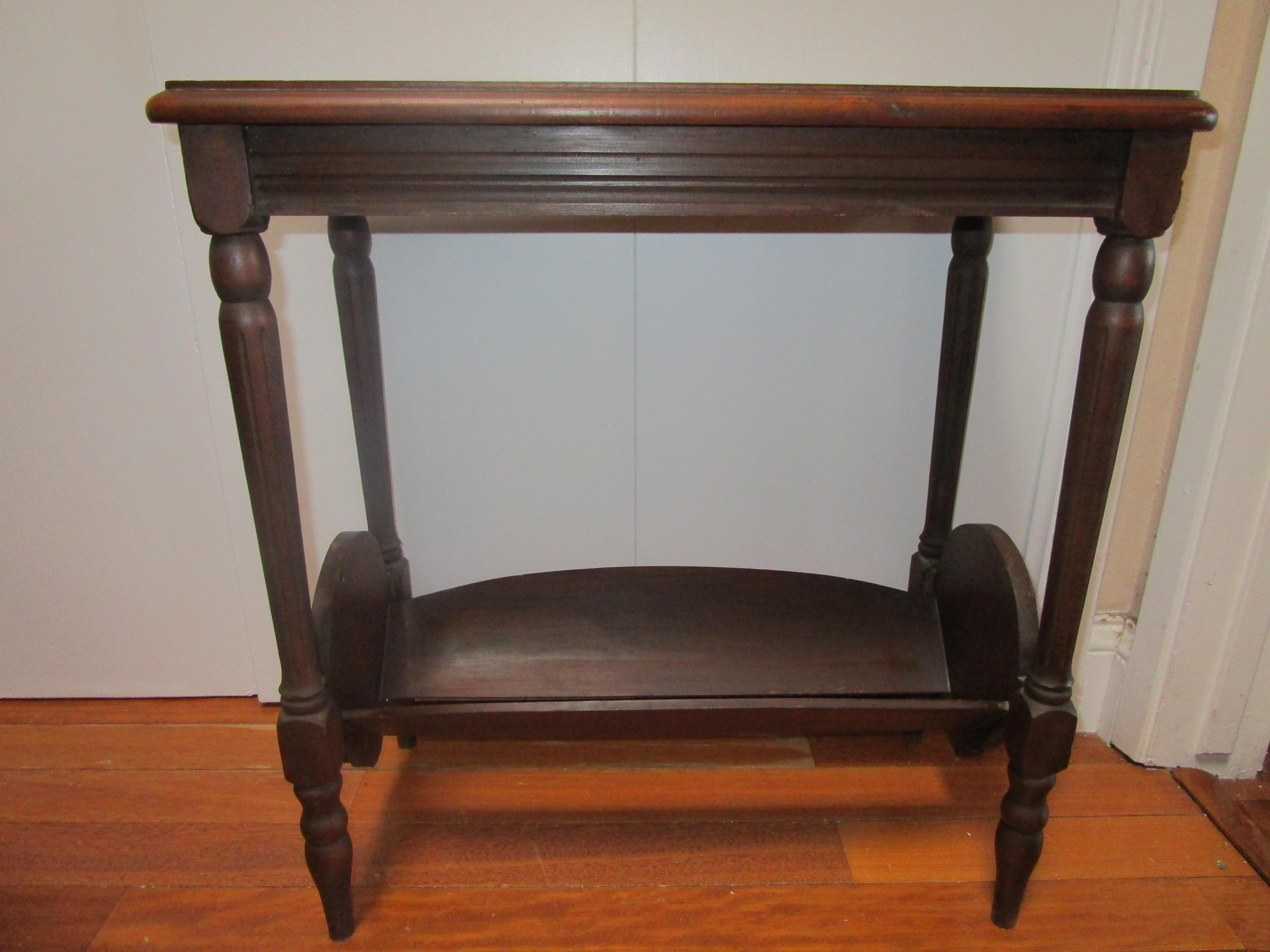 This is the most charming table, from the lower shelf for books, to the veneered wood and the serpentine details. This is an example of American furniture in its unusual forms that arose out of necessity, then faded for one reason or another. 
This