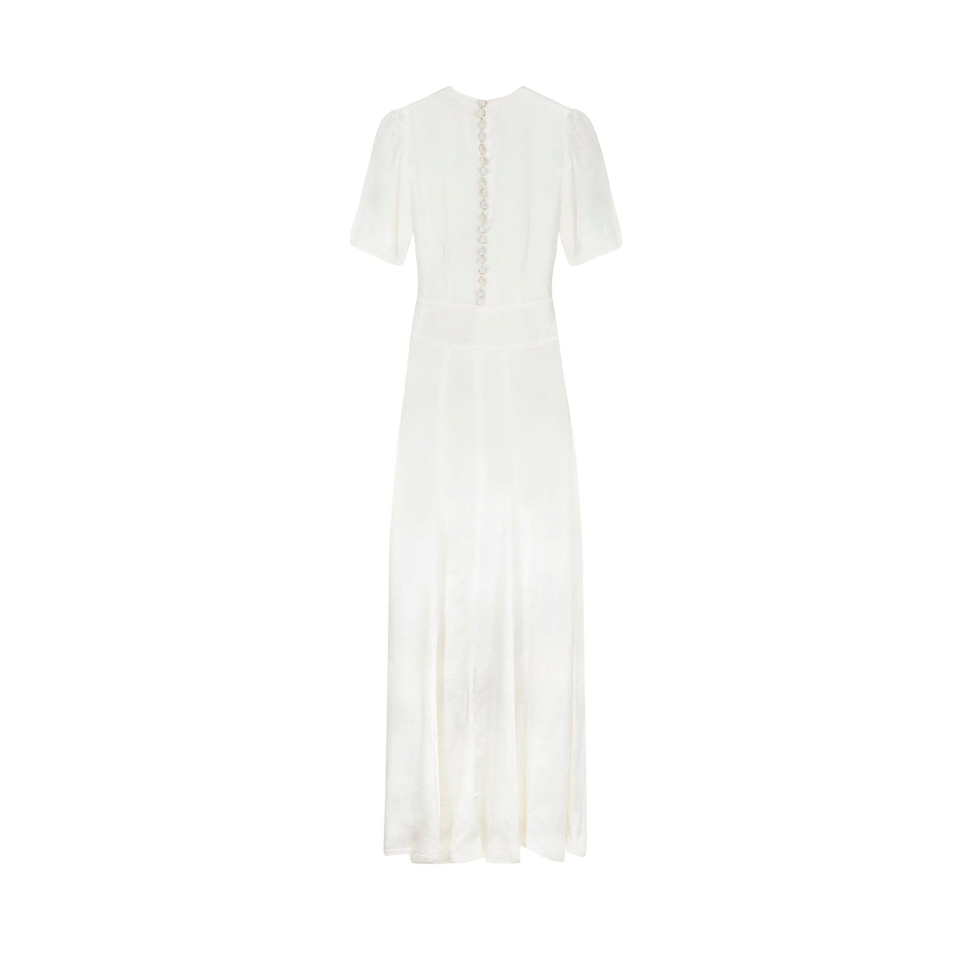 This antique wedding dress dates back to the mid or later part of the 1930s.  Tailored from what appears to be a silk jacquard which slowly reveals intricately woven, painterly botanicals in barely there impressions. The rounded neckline and