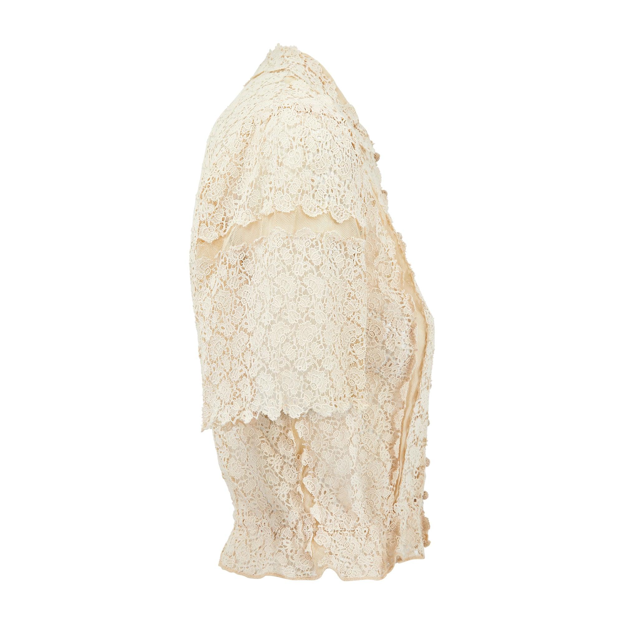 A stunning example of its kind, this cream blouse was handmade in the 1930s or conceivably earlier. Crafted from delicate pale cream lace and detailed with stripes of tulle net, it has pretty scallop hems along the Peter Pan collar and