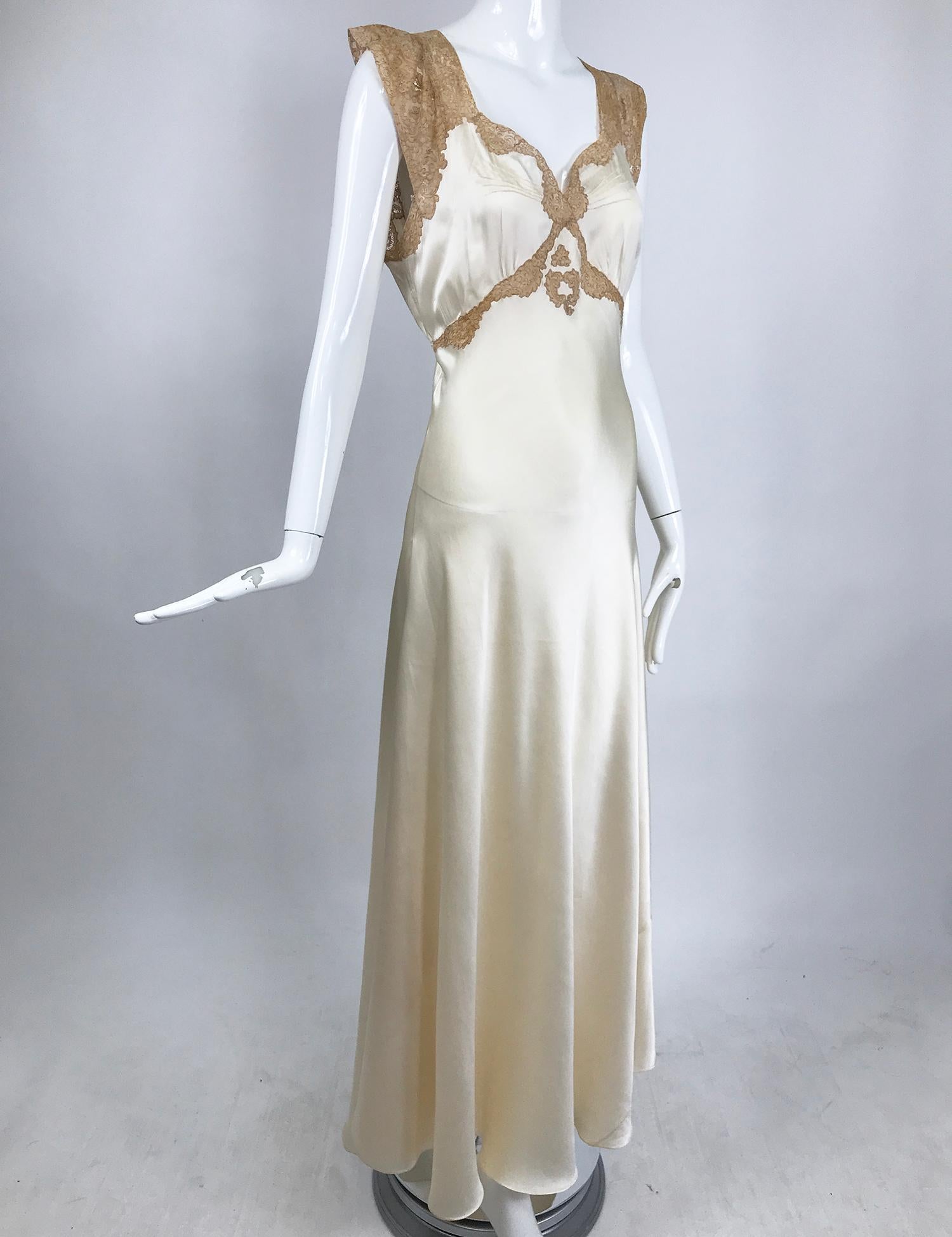 1930s cream silk charmeuse bias cut couture gown with ecru lace trim. This beautiful gown is beautifully hand made, the neckline is ecru re-embroidered alencon lace, perfectly cut and pieced and attached by hand with silk thread. The bodice has a V