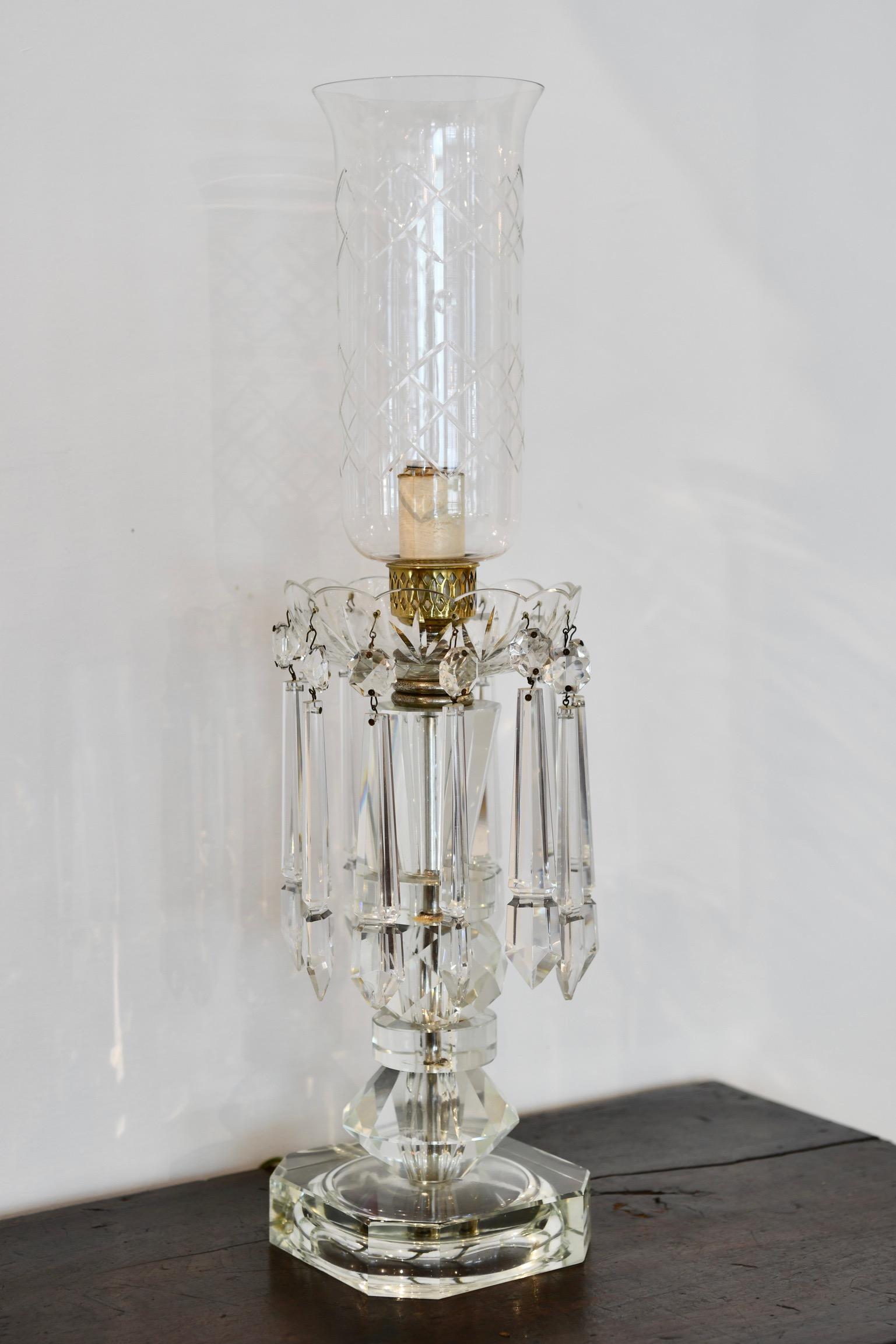 Crystal long prism and flare top hurricane lamp with lucite base, circa 1930. Prisms and hurricane are crystal. Prisms have small but minor chips and one missing. Another lamp with a small crack to the rim also available, sold separately.