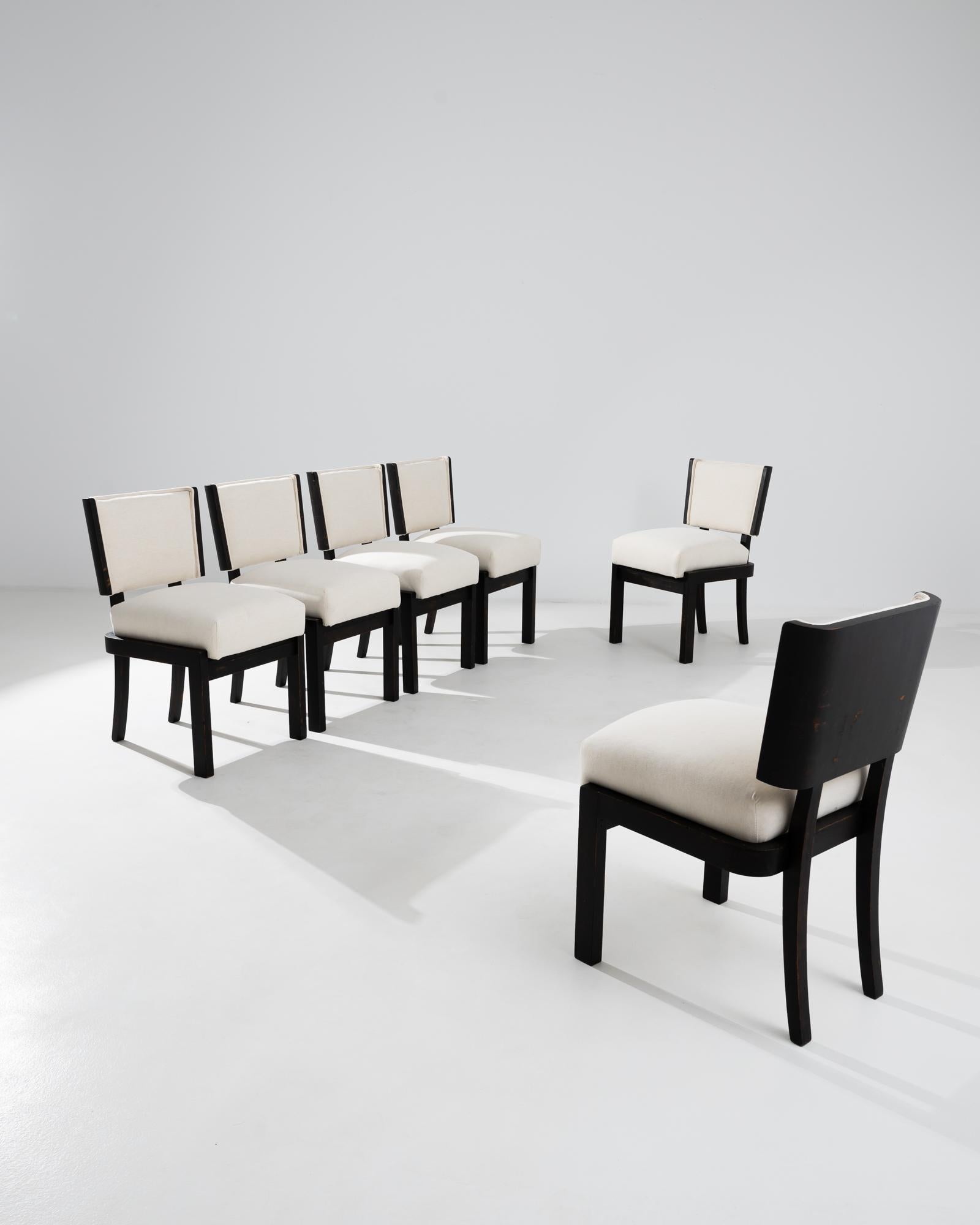 A set of wooden upholstered dining chairs from 1930s Czechia. This early 1930s set of chairs evokes the sense of geometric design of Central European Modernism, yet displays a rustic sensibility in its construction. A light patina runs the length of