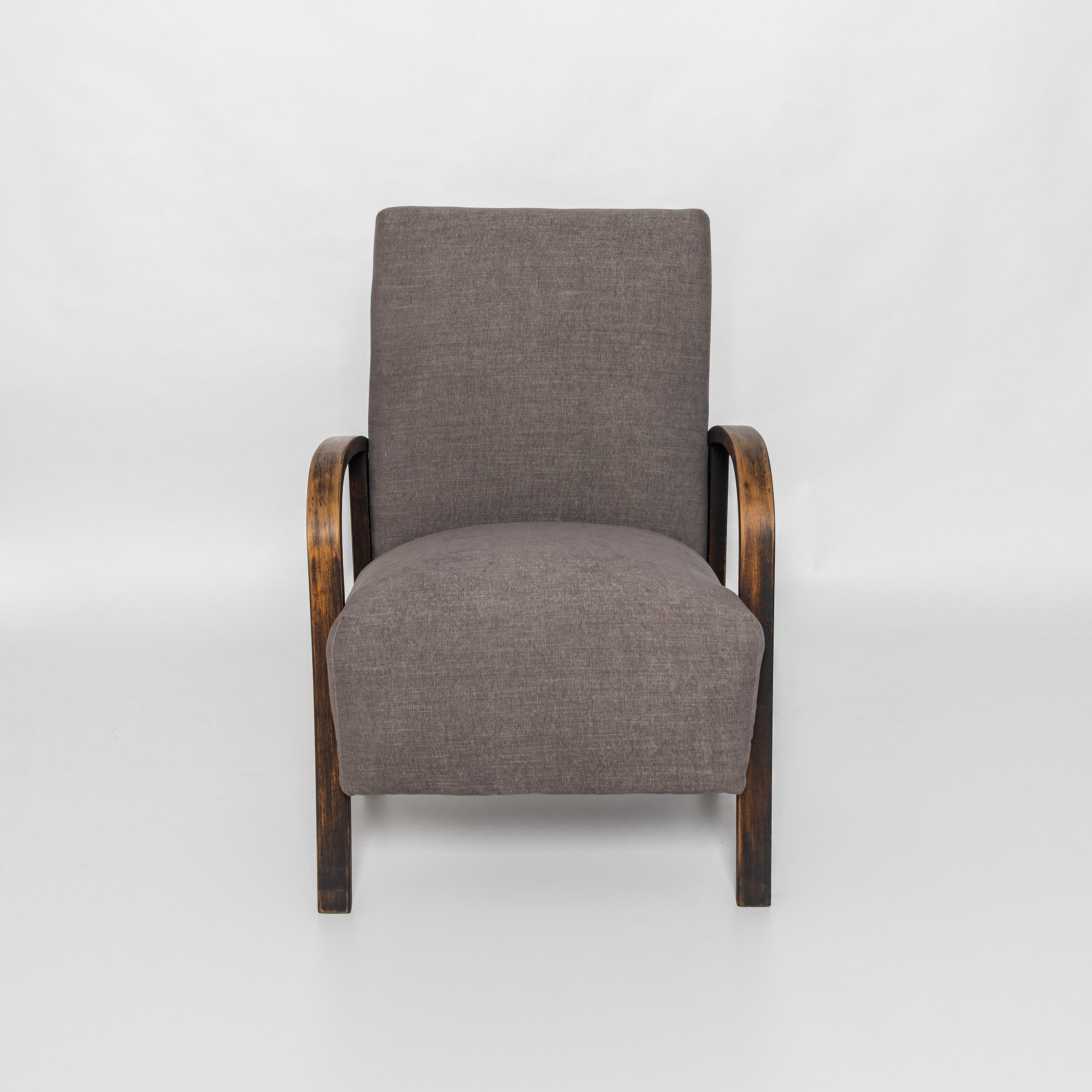 A Modernist inspired armchair from Czech Republic, circa 1960. A timeless approach that still looks contemporary and fresh. In the style of Jindřich Halabala with bent beech armrests and geometric legs, re-upholstered with a grey cotton-linen blend.