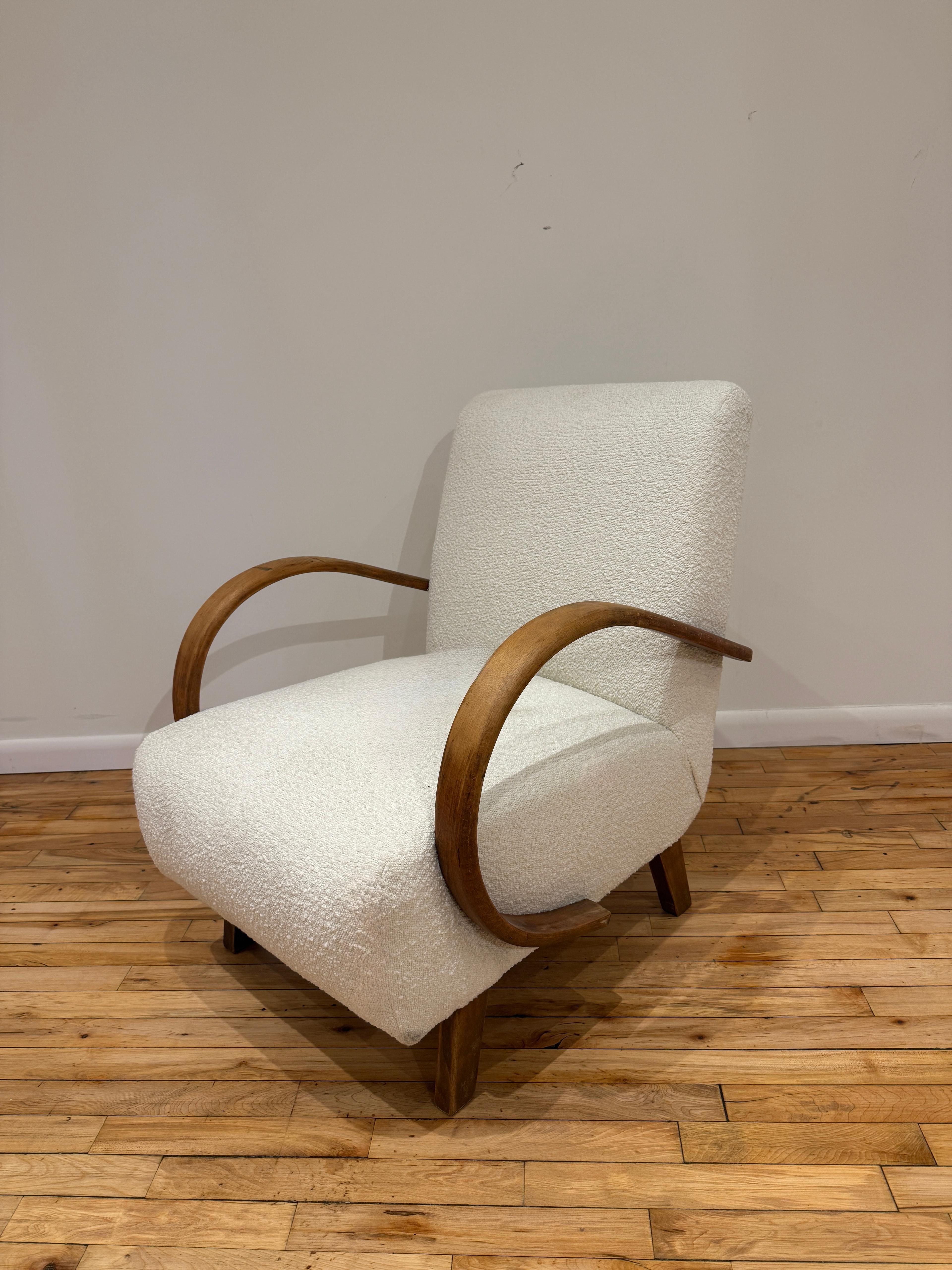 Este sillón checo de la década de 1930, obra de Jindřich Halabala, ejemplifica la elegancia y la innovación del diseño modernista temprano. Con sus característicos brazos curvados de madera curvada y patas en ángulo, la silla encarna el enfoque
