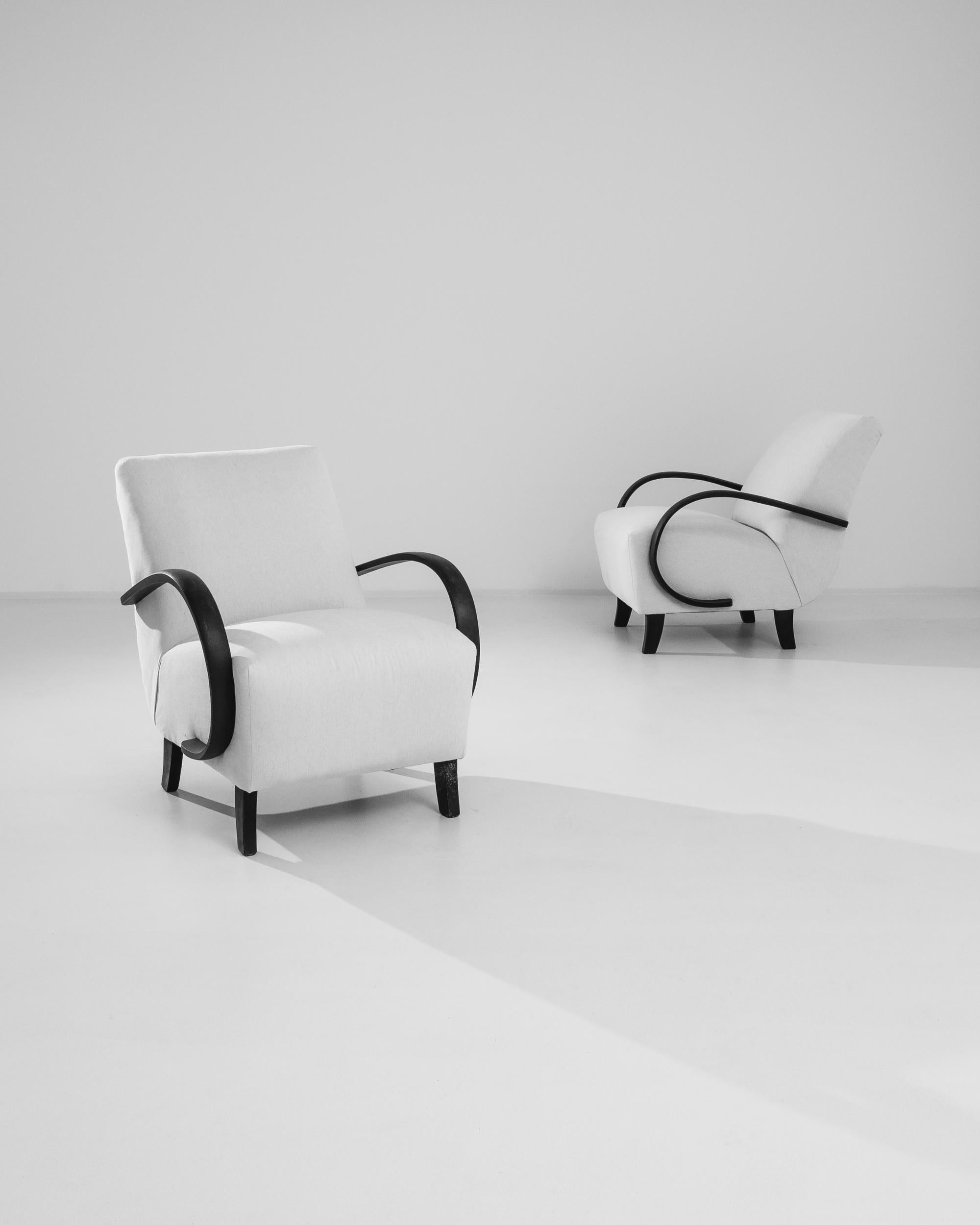 Replongez dans l'élégance des années 1930 avec cette paire de fauteuils tapissés tchèques du célèbre designer J. Halabala. Ces fauteuils sont dotés d'accoudoirs et de pieds en bois noir courbé, caractéristiques du style sophistiqué de l'époque. Le