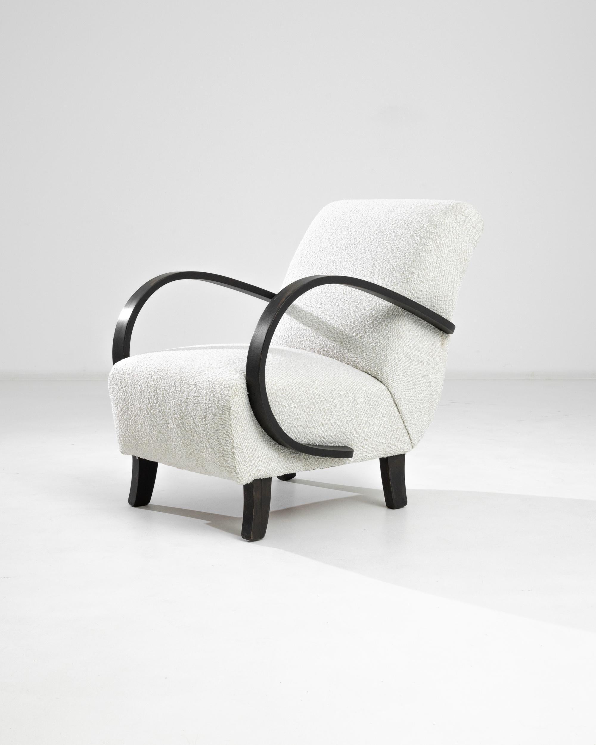 Ce fauteuil tchèque en bois des années 1930, réalisé par J. Halabala, est un exemple frappant du design moderniste du début du XXe siècle, alliant fonctionnalité et flair artistique. Le fauteuil est immédiatement reconnaissable à ses bras en bois