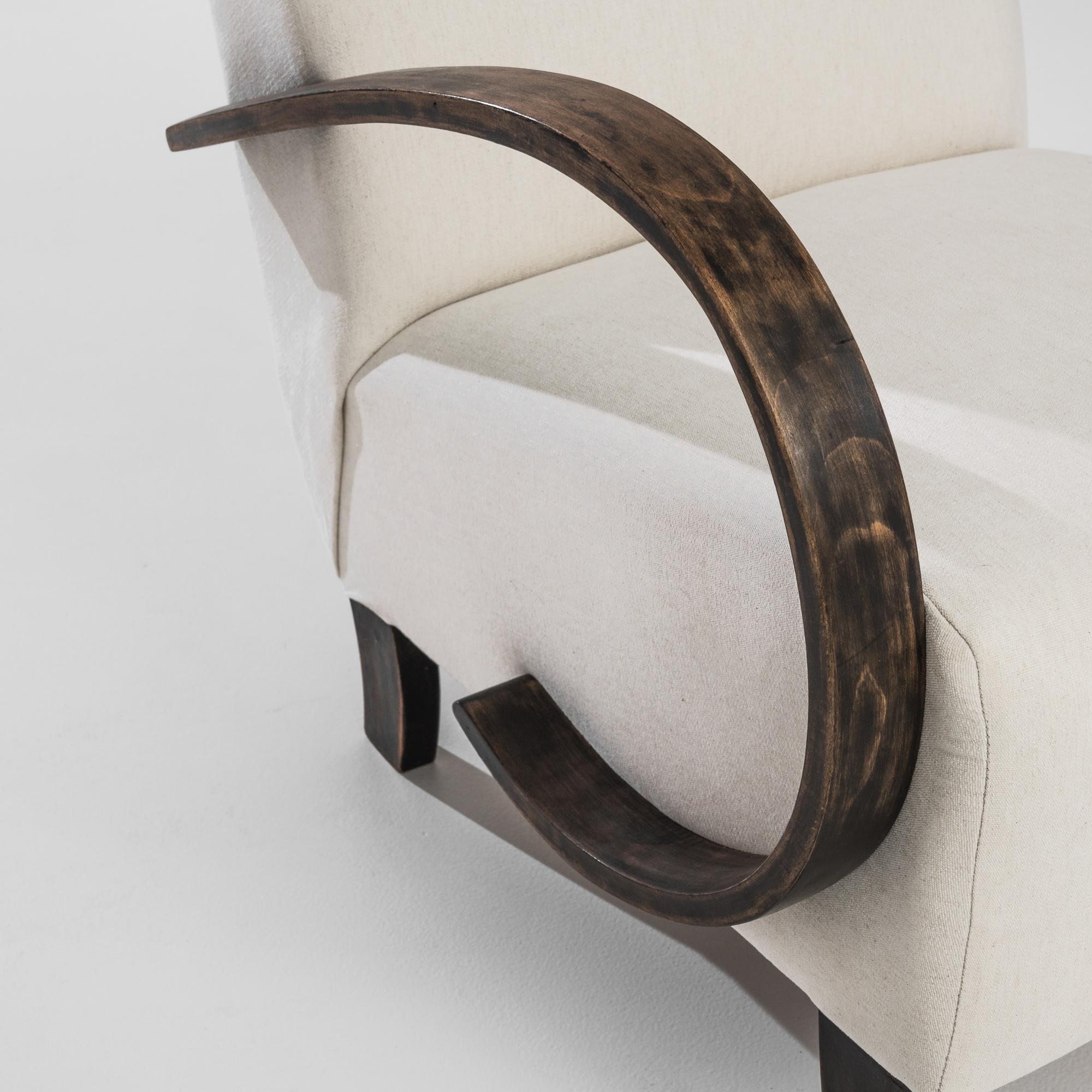 This pair of 1930s Czech Wooden Armchairs by J. Halabala is a remarkable example of timeless Art Deco design, showcasing the elegance and craftsmanship of the era. The chairs feature Halabala's signature sweeping bentwood arms, which create a