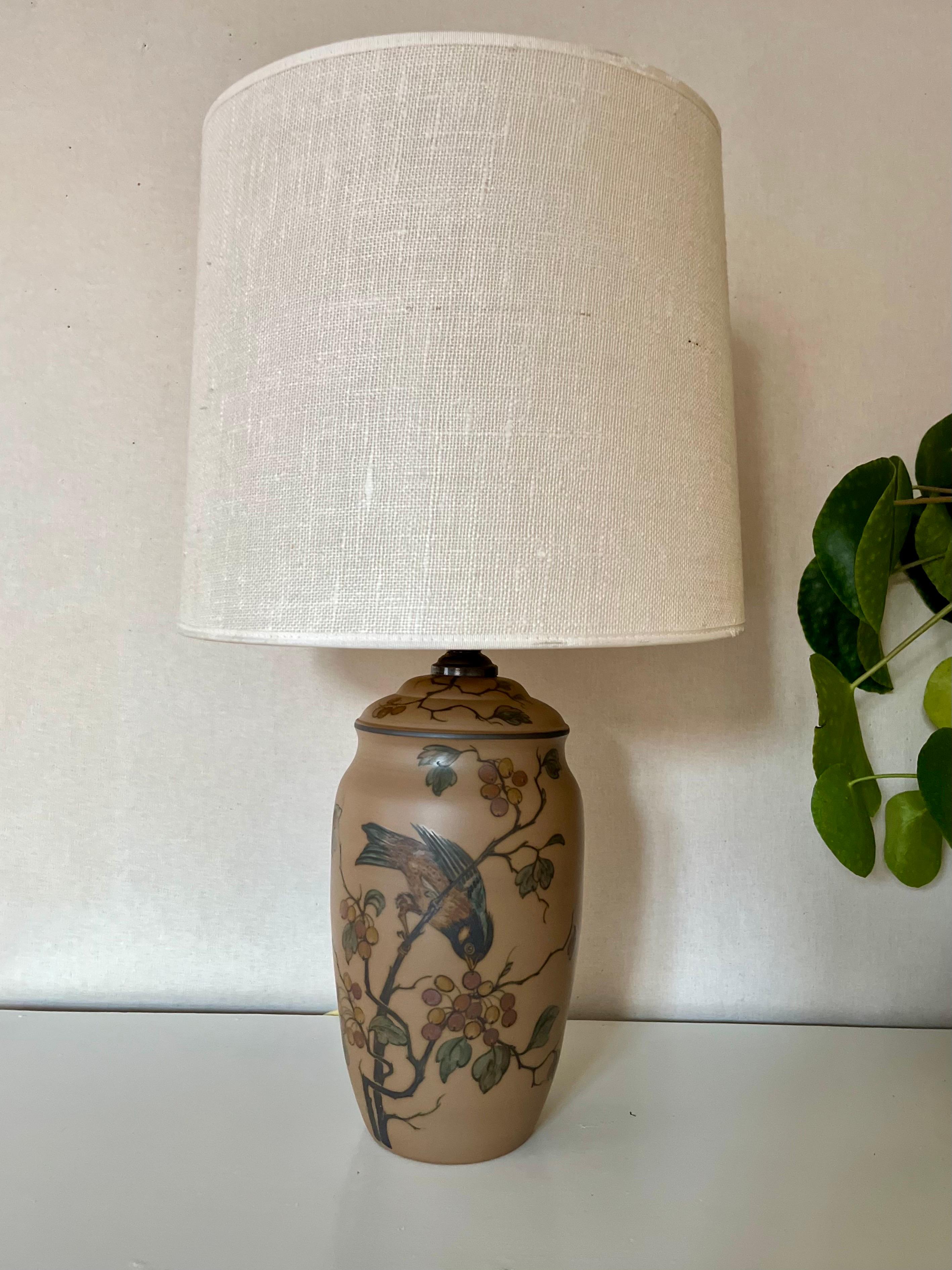 1930s Danish Art Nouveau ceramic table lamp. Handmade by L. Hjort's ceramic factory on the Danish island Bornholm that is famous for it's outstanding ceramic workshops. 

Hand decorated with a bird picking on berries, branches and leaves in earthy