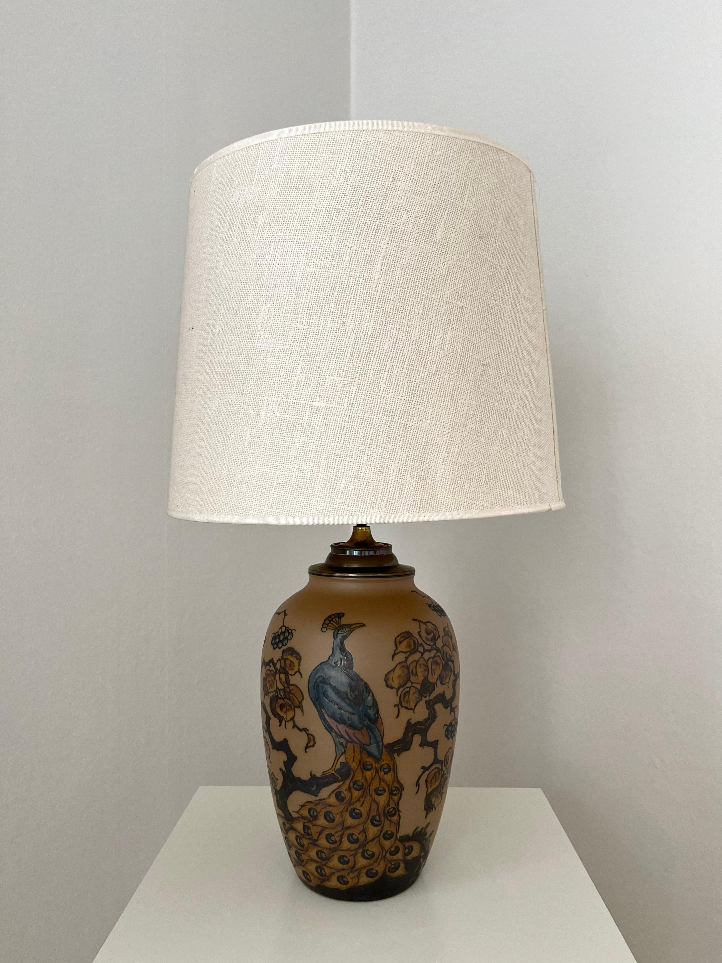 Art nouveau Danish ceramic table lamp with hand decorated peacock, made by L. Hjort ceramic factory. This tall table lamp is from the 1930s and in very good condition. Originally made in 2 pieces, a floor vase and an electric part made from brass,