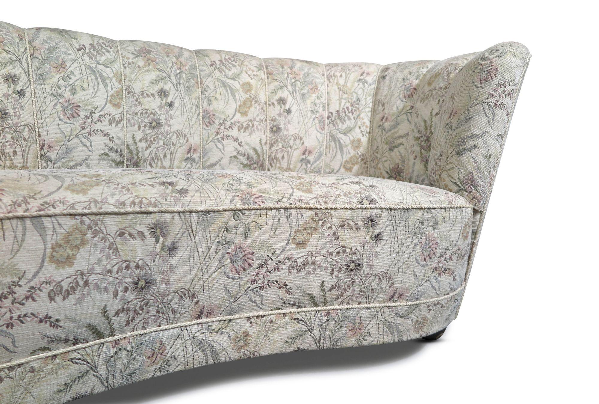 1930s Danish channel back settee crafted of a solid wood frame with eight-way hand-tied springs, horsehair and cotton padding, this masterfully crafted curved-back settee is covered in the original 1930's floral pattern. In good vintage condition,
