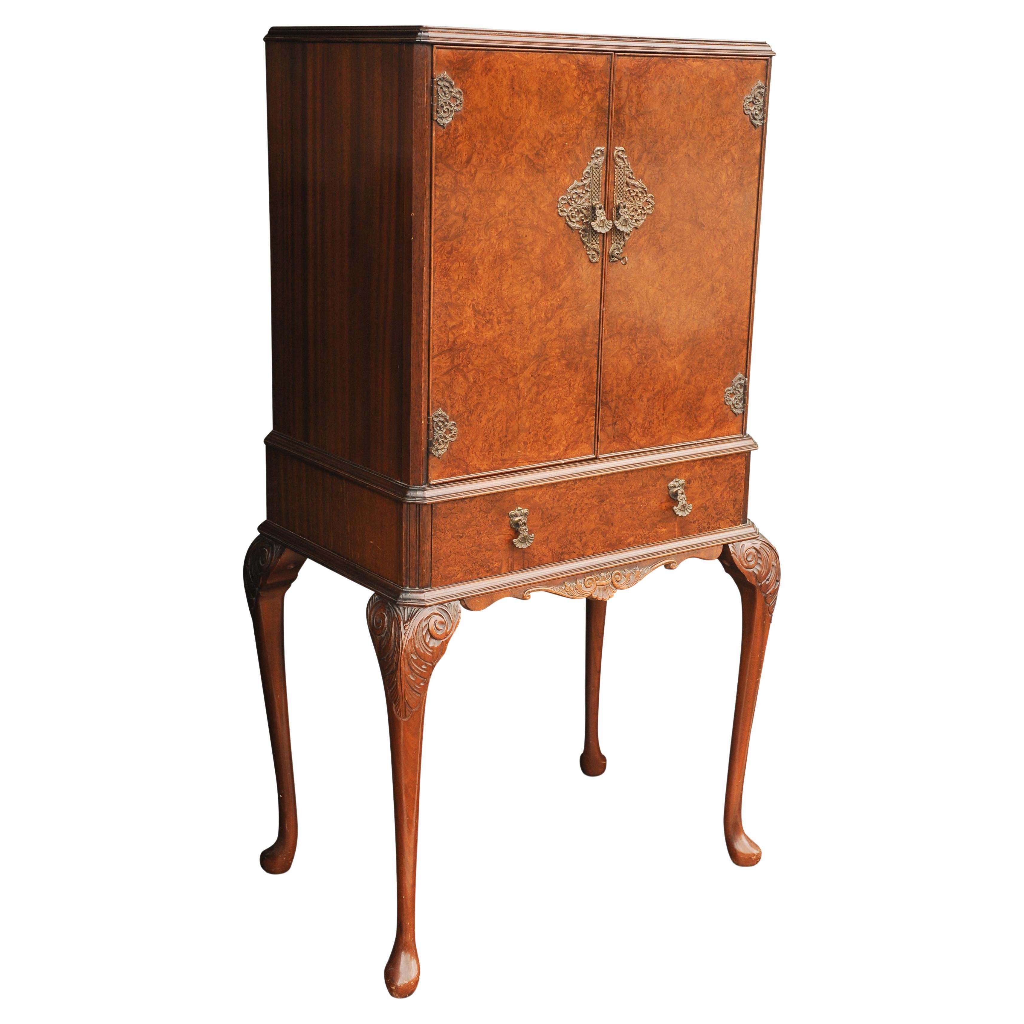 1930s Art Deco Decadent Epstein Cocktail Cabinet Hand Crafted Burr Walnut With Ormolu Carvings

A beautiful cocktail cabinet fit for entertaining guests.
Fitted with interior mirror with lights lighted interior, and a pull out drinks shelf for